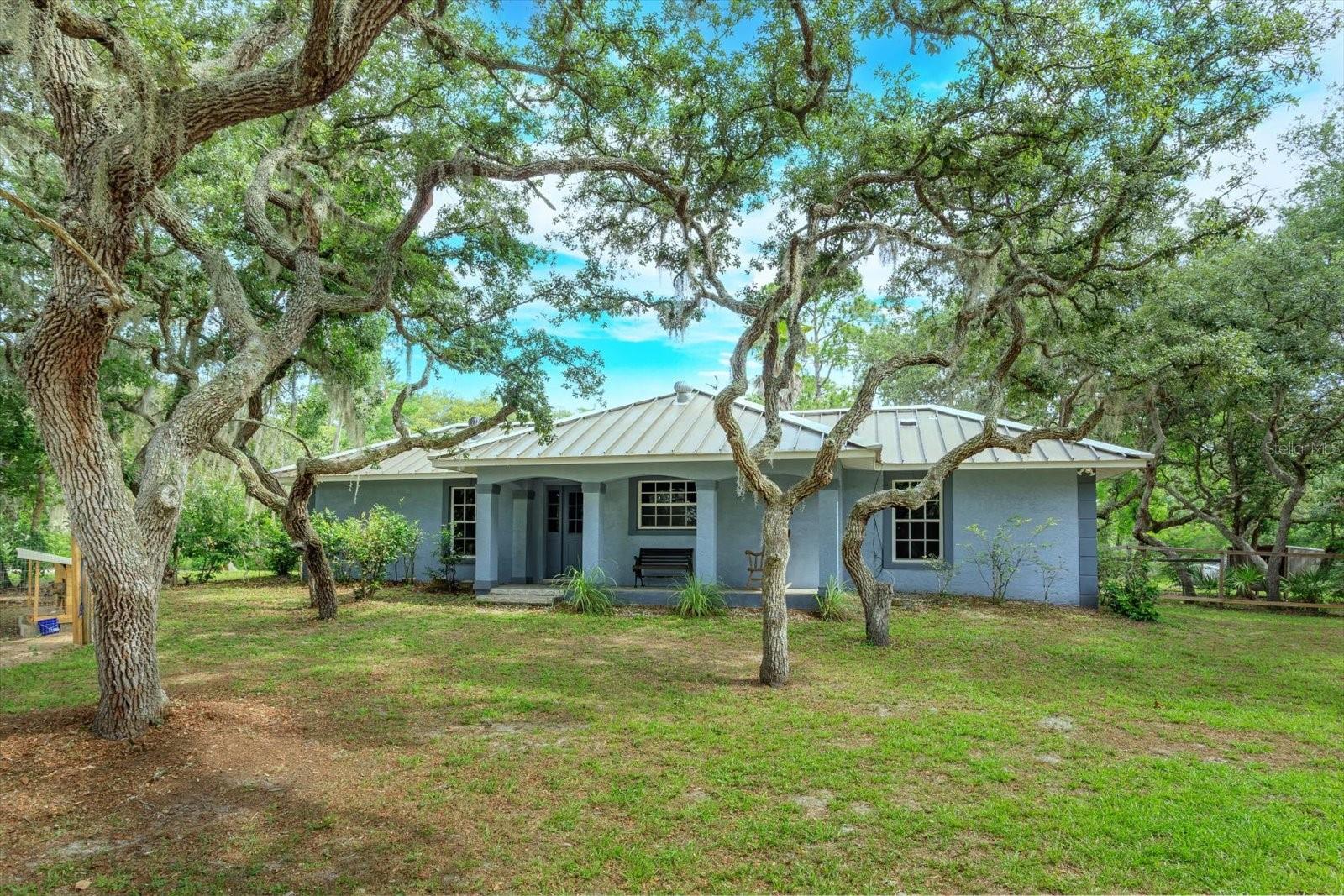 6+ Acres feature a A lovely 2 bedroom/2 bath concrete block home in a beautiful country setting. Open living and dining area with vaulted ceilings, wood and tile floors, decorative non burning fireplace. French doors open to a 20X16 Patio. Great property with 2 outbuildings and room to roam!. Don't Miss-this will go fast.
