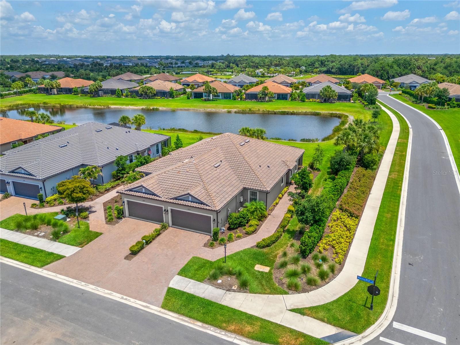 Move-In Ready Luxury Upgraded Premium Waterfront End Unit Villa in Skye Ranch. Experience luxury living without the wait of construction. Located in the highly desirable gated Esplanade at Skye Ranch, this impeccably upgraded Taylor Morrison "Ibis" model sits on a premium waterfront lot. The open-concept design features tons of upgrades: Plantation shutters, tray ceilings in primary suite, dining room & study, 5" crown molding in living, dining and kitchen, 8' interior doors, 8' Crystalline Front Door that floods the entryway with natural light, 5" base, luxury vinyl floors, tile floors, ceiling fans through out, and sophisticated quartz countertops. Two spacious ensuite bedrooms offer ultimate privacy, while a versatile flex room easily serves as a home office, den, or third bedroom. A chef’s kitchen boasts stainless steel appliances including French Door refrigerator, gas stove, upgraded LED under counter lighting, stunning tiled backsplash, premium cabinetry, and an expansive quartz counter perfect for entertaining. You will have peace of mind knowing there is a high voltage serge protector on HVAC CAPTURA UVC Germicidal Air Purifier, hurricane shutters, kitchen sink water filtration system, tankless water heater, and it's a Smart Home. The indoor laundry room features upgraded 42" upper cabinetry, lower cabinetry, laundry sink, and GE Washer and Gas Dryer. The garage floor is even upgraded with acrylic stain and sealed floor plus there is a keyless pad for the garage door. Outside, enjoy serene water views on the extended paved screened patio with neighbors on one side, providing unparalleled comfort and privacy. Exclusive access to Esplanade’s resort-style amenities. "The Hub" offers state-of-the-art techno gym equipment, variety of classes including yoga flow, mat Pilates, and guided meditation. Grab a coffee at the on-site cafe', browse boutique style retail, or relax at the resort pool with cabanas. There is also pickleball, bocce and tennis courts, nature paths and trails, fireside seating, putting green, corn hole and a bark park. Situated just minutes from Sarasota’s world-class beaches, premier shopping, and dining, this home offers the ultimate Florida lifestyle. Schedule your private showing today and discover the epitome of Sarasota living.