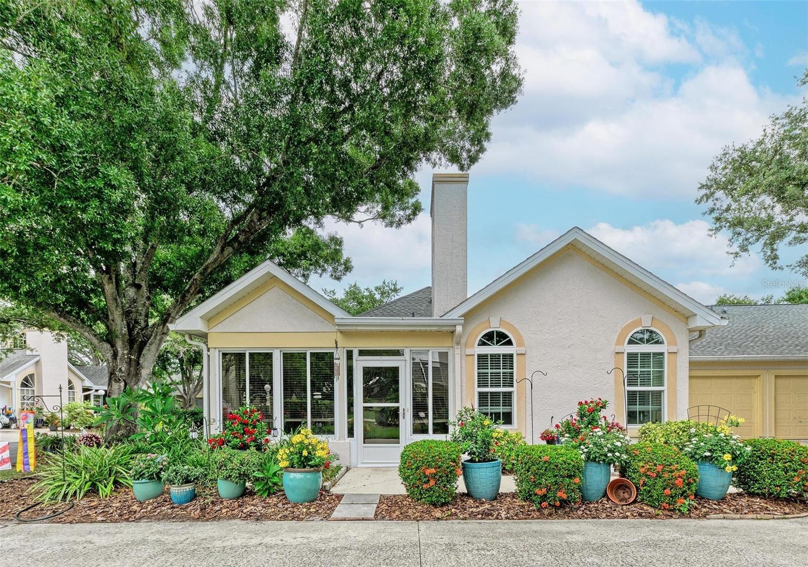 Imagine maintenance-free vacation living. This charming cottage-style villa at 4512 Citation Lane in Sarasota sits proudly on a beautifully landscaped corner lot, surrounded by established oak trees that lend the community a picturesque, park-like feel. From the moment you arrive, the curb appeal and peaceful cottage vibes set the tone for a cozy and inviting home that has been thoughtfully updated and meticulously maintained.
Inside, the kitchen and baths have been completely renovated with beautiful, modern finishes that complement the home’s character. There is NO CARPET anywhere—only durable and stylish vinyl plank and ceramic tile flooring throughout, creating a clean, cohesive look that is both low-maintenance and pet-friendly. Shiplap accents and custom bead board ceilings throughout add to the cottage charm, giving each room a sense of warmth and designer detail.
The floor plan offers ample storage space along with the convenience of an attached garage, making day-to-day living both practical and comfortable. A wood-burning fireplace becomes the focal point on those rare chilly Florida nights, adding ambiance and a true sense of home. The glass-enclosed lanai is under air, providing additional living space that can be enjoyed year-round—perfect for a cozy reading nook, hobby room, or sunlit sitting area. HVAC unit is from 2021.
Calumet is an intimate, maintenance-free community of just 66 homes. The HOA takes care of exterior painting, mowing, edging, trimming, irrigation, and outdoor pest control, allowing you to enjoy a worry-free lifestyle. Residents also have access to a community pool and fitness center, enhancing the neighborhood’s relaxed and friendly atmosphere.
The location is exceptionally convenient, just minutes from I-75 and Doctors Hospital, with easy access to shopping, dining, Gulf beaches and all that central Sarasota has to offer. Whether you’re seeking a primary residence or a seasonal retreat, this beautifully updated cottage-style villa in Calumet at Centergate combines charm, comfort, and convenience in one special package.