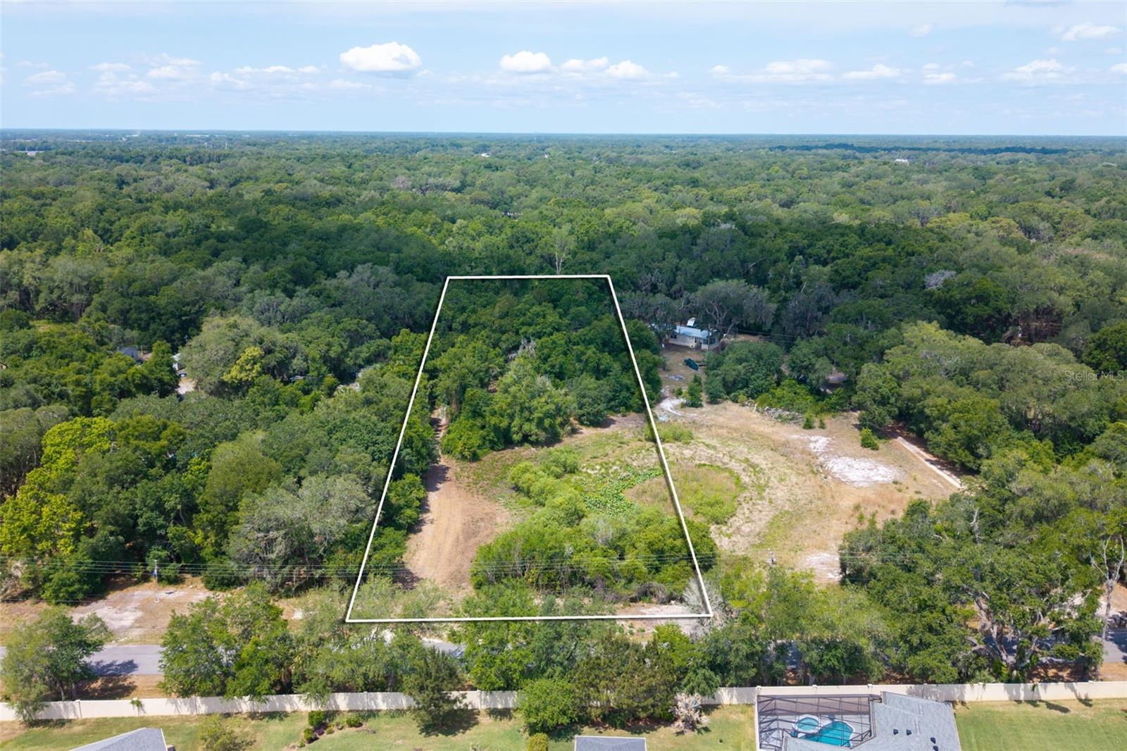Located just minutes from The Villages, this 2.50 acre parcel offers a great combination of space, location, and readiness.

The property has been cleared of structures and is currently vacant, providing a straightforward path for its next use. Impact fees have already been paid, offering a valuable cost savings moving forward.

A pond sits at the front of the property, adding to the natural setting and overall appeal. There is already a well drilled, electric available and a septic system in place; however, the buyer will need to verify condition and functionality.

Situated in Sumter County, this location offers convenient access to nearby shopping, dining, and everyday amenities while still maintaining a more open, spacious feel.