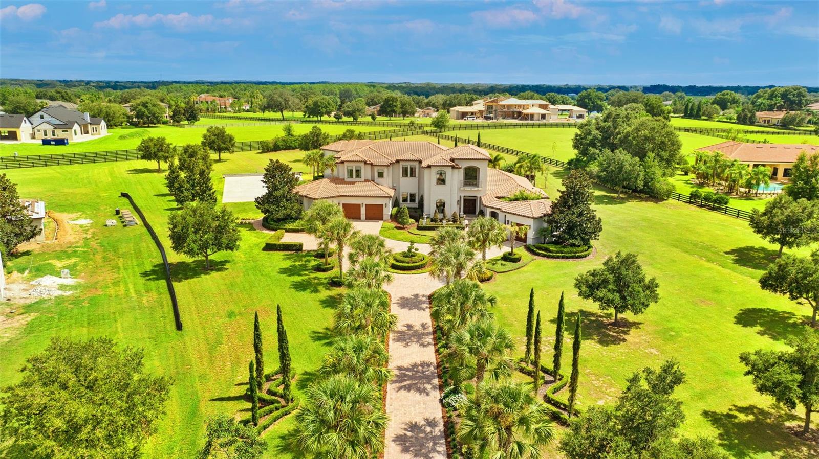 Now is the moment to secure one of Tampa Bay’s most compelling equestrian-capable luxury estates—a classic Tuscan residence offering exceptional indoor–outdoor living, multi-acre usability, and direct access to Stonelake Ranch’s private riding trails. This timeless estate features over 7,782 sq ft of air-conditioned space and 11,278 sq ft under roof, including seven ensuite bedrooms in the main home and a detached two-story casita with two private suites ideal for guests, extended family, or equestrian team members. The flowing Tuscan-inspired floor plan opens through a dramatic vestibule into an expansive great room with soaring ceilings and elegant architectural details. Corner pocket sliders disappear completely, creating a seamless transition from the living room to the outdoor kitchen, dining area, and covered lounge overlooking the terraced pool—perfect for entertaining or relaxing after long riding days. The gourmet kitchen features dual islands and luxury gas appliances, while the first-floor primary suite offers direct pool access and a spa-style bath. For equestrians, the property is unmatched: a large pre-positioned concrete pad is ideally suited for a custom barn, and the surrounding acreage easily accommodates a regulation riding arena, corral space, and turnouts. The estate is bordered on two sides by private riding trails, allowing riders to explore miles of scenic paths directly from their land. Perched over 70 feet above sea level, the property delivers uncommon elevation, long-term stability, and enduring value. Ideally located between Ocala and Wellington, it serves as the perfect base for competitive riders while offering Tampa’s full spectrum of amenities. Stonelake Ranch enhances the lifestyle with direct access to private Lake Hendry, ideal for paddleboarding and quiet waterfront enjoyment, and nearby Lake Thonotosassa, the region’s largest freshwater lake—perfect for fishing, boating, and sunset cruising. Residents enjoy a private boat ramp, 24-hour staffed security, private roads, a lakeside lodge, fitness center, tennis and pickleball courts, RV/boat storage, and a 100-acre meadow. Its strategic location is especially valuable for business owners and entrepreneurs: quick access to I-4, I-75, and the Selmon Expressway offers seamless reach to downtown Tampa, the Westshore district, Brandon, Lakeland, and Orlando, ideal for managing teams, logistics, or multi-location operations. Proximity to major corporate hubs, logistics centers, the Port of Tampa, and Tampa International Airport supports travel-intensive schedules. Nearby top-tier medical institutions include Tampa General Hospital, Moffitt Cancer Center, AdventHealth, and USF Health, with convenient interstate access to Lakeland Regional Health, Orlando Health, ORMC, and AdventHealth Orlando, making it an exceptional home base for medical professionals and healthcare executives. Located just 20 minutes from downtown Tampa, 30 minutes to TPA, and 45 minutes to St. Pete’s beaches, this estate blends privacy, accessibility, and equestrian excellence. With equestrian-ready infrastructure, classic Tuscan architecture, unmatched indoor–outdoor living, and rare multi-lake access, it stands among Tampa Bay’s most desirable luxury offerings.