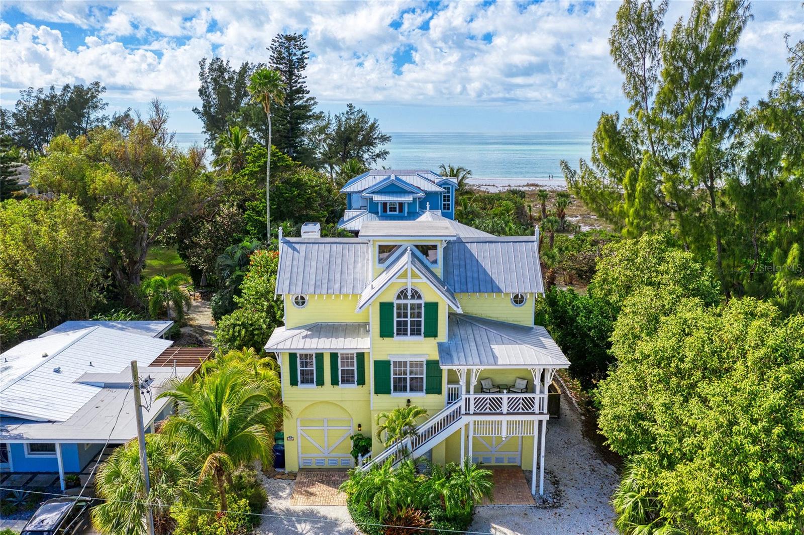 ~~~~ PRICE IMPROVEMENT ~~~~. Stunning Family Vacation Home in Anna Maria, FL!  Yellowbird, 705 North Shore Dr., Anna Maria.  Nestled on the beautiful North End of Anna Maria Island, Yellowbird is a luxurious family vacation home that embodies old Florida charm and offers an ideal location just a quick stroll from the stunning white sandy beaches of the Gulf. This spacious retreat features 4 bedrooms and 3.5 bathrooms, providing the perfect haven for family gatherings. Accommodating everyone comfortably, the sleeping arrangements include 2 bedrooms with king beds, 1 Queen bedroom, 1 bedroom with a Queen Murphy bed and a bonus loft with 1 Full, and 1 Twin Trundle bed.  As you enter, you’ll be greeted by an expansive, modern kitchen that has been totally remodeled with new quartz counter tops, cabinets and high end appliances. It looks amazing! This open-air concept is designed for creating lasting family memories, with ample seating for large gatherings, including dining options around the new beautiful island in the kitchen.  The inviting family room serves as the perfect spot for game nights or movie marathons, complete with a 55-inch Smart TV.  Step outside to discover an outdoor paradise, where you can relax by the resurfaced private heated pool, illuminated with LED lights. Surrounded by new limestone pavers, the pool area features an outdoor shower and a dedicated game room with a ping pong table. For the nights you want to dine alfresco, there is an outdoor gas grill, plumbed to an under ground 500 gallon propane tank.  The updated tropical tiki hut and comfortable seating create an idyllic atmosphere for unwinding all day or to cool off after a perfect day at the beaches of the Gulf. Multiple decks and verandahs offer breathtaking sunset views, making every evening a memorable experience as the light come through the newly installed hurricane windows  and doors throughout.  Convenience is key at Yellowbird, highlighted by an elevator from the garage to the 2nd floor, a laundry room with a washer and dryer.  Each bedroom is equipped with Smart TVs and ceiling fans, ensuring comfort for every guest. The master bedroom, located on the main living area, includes a custom walk-in closet and private deck access overlooking the pool, while the third floor features three additional inviting bedrooms, including a king bedroom with an en-suite bathroom, a queen bedroom, and a room with a queen Murphy bed. Kids will enjoy the loft area on the top floor, featuring a full bed and twin trundle, accessed via a ladder.  With 3 driveway spaces and 2 garages equipped with door openers and remotes, parking is never a concern.  Yellowbird is not just a home; it’s your very own retreat where morning coffee on the deck and sunset views become a part of your daily routine. Located within easy walking distance to shops, restaurants, and the free island trolley, you can explore the vibrant charm of Anna Maria Island at your leisure.  Your dream beach vacation home awaits at Yellowbird—come and experience the magic for yourself and start living your Anna Maria Life.