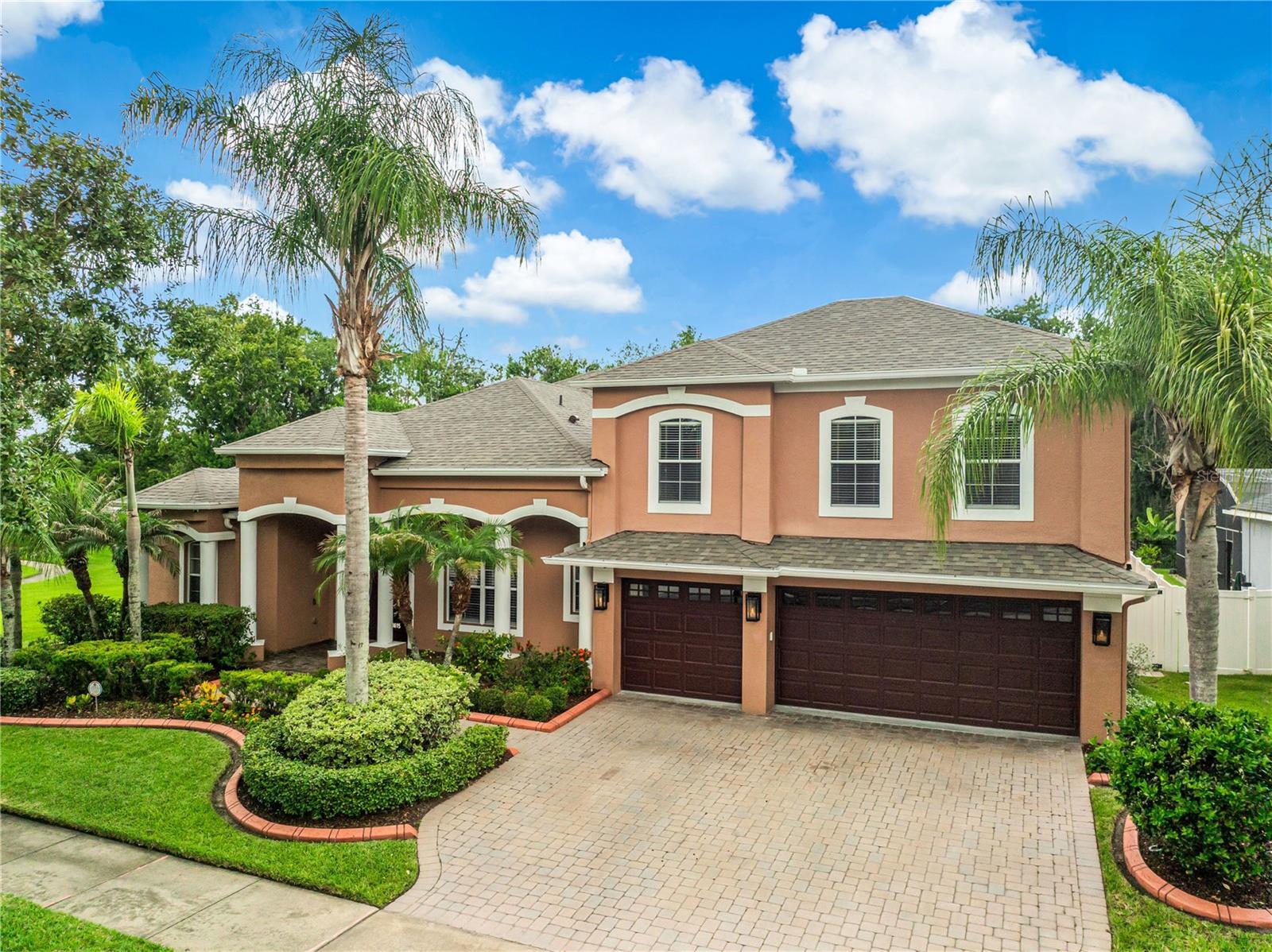 Experience the perfect blend of elegance and resort-style living in this exceptional estate located in the prestigious gated community of Warwick at Vista Lakes! Perfectly positioned at the end of a quiet cul-de-sac and backing onto a serene conservation area, this remarkable home offers a rare combination of privacy, generous living spaces, and incredible flexibility, with no rear neighbors! As one of the largest floor plans available in Vista Lakes, this exceptional residence offers an impressive layout designed to accommodate both comfortable everyday living and grand-scale entertaining. The grand foyer welcomes you with soaring ceilings, elegant architectural details, and stately columns that lead into the formal dining room, creating a warm and impressive first impression.The beautifully updated kitchen is both stylish and functional, featuring white cabinetry, granite countertops with bar seating, a walk-in pantry, and newer appliances, making it the ideal space for everyday living and entertaining friends and family! The spacious primary suite is a private retreat, offering peaceful views of the pool through large windows, a generous walk-in closet with custom built-ins, and a luxurious ensuite bathroom complete with dual vanities, a relaxing garden tub, and a separate walk-in shower. Designed for today’s lifestyle, the home offers exceptional flexibility. Bedrooms two and three have been thoughtfully converted into a private in-law suite complete with its own kitchen and living area, perfect for extended family or a private retreat for college-aged students. Upstairs, the expansive bonus room provides even more flexibility; it can easily serve as a media room, game room, fitness area, playroom, or be reconfigured to accommodate an additional bedroom while still maintaining ample recreational space. Recent updates add both style and peace of mind, including luxury vinyl plank flooring throughout the main living areas, beautiful wood flooring on the staircase, a water heater (2025), A/C unit (2024), water softener system (2023), and brand new roof (2026)! 
Also, a portion of the third garage has been thoughtfully converted into a private office, creating the perfect workspace for those who work from home while still preserving valuable garage space for parking and storage. Every detail of this home has been designed with comfort, functionality, and everyday luxury in mind! Step outside to your own private tropical oasis overlooking the conservation area. Beyond the sparkling pool awaits a lush tropical landscape filled with an impressive variety of mature fruit trees. More than a beautiful landscape, this backyard offers the rare opportunity to enjoy fresh, homegrown tropical fruit throughout the year, bringing the flavors of Florida right to your doorstep while creating an unforgettable outdoor living experience! Residents of Vista Lakes enjoy an exceptional collection of resort-style amenities, including a private 2-mile lakeside walking trail, clubhouse, fitness center, swimming pools, water slide, tennis courts, soccer and baseball fields, boat docks, a fishing pier, and scenic lake access. Conveniently located just minutes from shopping, restaurants, 417, 408, and 528 highways. Combining luxury finishes, flexible living spaces, thoughtful updates, and an unbeatable location, this extraordinary home offers a rare opportunity to enjoy the very best of Central Florida living. Come see it today!