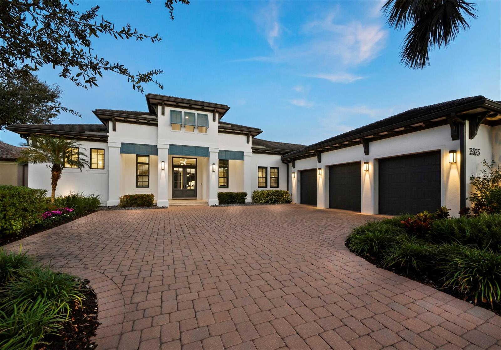 Situated on a beautifully landscaped half acre with preserve views in the award-winning Founders Club golf community, this stately coastal home boasts abundant space and luxurious features that include exquisite design enhancements as well as functional upgrades. Built in 2019, the home blends modern scale and style with classical elements of West Indies architecture for an ideal balance of comfort and elegance. Within the last year, significant improvements to the already impressive interior include complete repainting, new light fixtures and fans throughout, new solar shades in the primary suite and living room, new carpet in guest rooms, and fabulous wallcoverings by Phillip Jeffries and Scalamandre in numerous spaces. Creating the immediate impression of an island estate, oversized double doors lead from the paver courtyard to an airy foyer and great room that features a soaring, 16’ coffered ceiling and seamless access through full-height glass sliders to the elegant covered lanai beyond. Designed for an idyllic indoor-outdoor lifestyle and entertaining convenience, walls of glass open the home easily to more than 1,100 square feet of fully screened exterior living space that surrounds the heated pool and spa with distinctive spaces to lounge and dine. Inside, more than 3,400 A/C square feet of interior living space comprise three bedrooms, three and a half bathrooms, a private office, a roomy separate den that opens directly to the covered terrace, and a gourmet kitchen with an oversized island and counter seating, topline appliances, and a walk-in pantry. The kitchen, overlooking the great room and with beautiful sight lines to the scenic preserve, features double wall ovens, a gas range with pot filler and bespoke wood-clad vent hood, farmhouse-style porcelain sink, and granite counters. A spacious dining area alongside the kitchen flows to the family room and enjoys open access to the lanai and outdoor kitchen, fully appointed for ultimate convenience with a sink, beverage refrigerator, gas grill and hood. Situated on the other side of the home from the guest quarters, the owners’ suite is a roomy retreat that enjoys its own private access to the lanai and picture-perfect natural vistas, with two walk-in closets and a resort-style bathroom that includes a separate water closet, dual vanities, a free-standing soaker tub and an enormous walk-in shower outfitted with two shower heads and an integrated bench. Throughout the home, an open concept and oversized windows welcoming natural light underscore coastal comfort, with details like crown molding, custom millwork, tray ceilings, and travertine floors cuing luxury sophistication. New shutters outside, a whole-house generator, reverse osmosis and water filtration, and impact windows add further value. The pristine 3-car garage is climate controlled and equipped with custom Closet Tec cabinetry that is also installed in the adjacent storage room. Located within an easy drive of Downtown Sarasota and the cultural appeal of the city and keys, the Founders Club is renowned for its beauty and amenities, including a 24-hour guarded gate, gorgeous tropical landscaping, Har-tru tennis courts, additional racquet and sports courts, and more. Optional membership in the golf club adds access to a clubhouse with full-service dining and state-of-the-art fitness facilities and an 18-hole championship course.