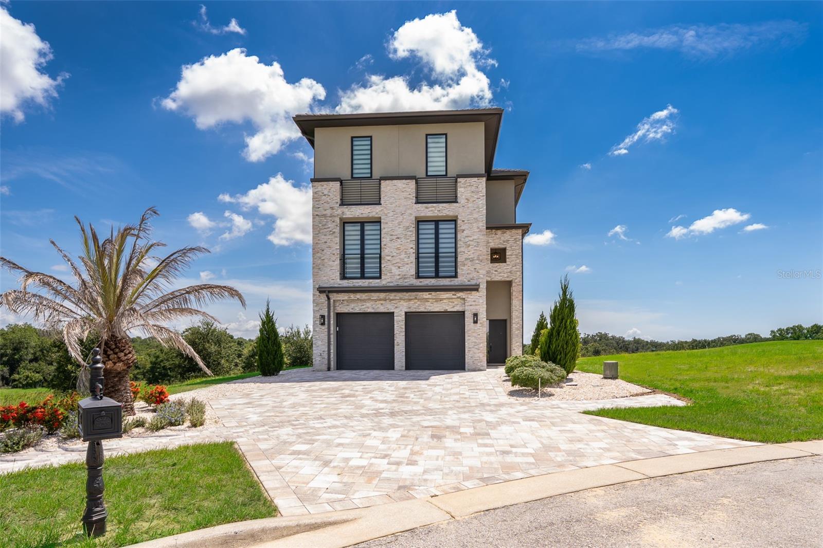 Step into elevated living in this extraordinary corner-lot, custom-designed estate, within a cul-de-sac, in the exclusive guard-gated community of Bella Collina. Spanning three luxurious levels, this 4BR, 5 Full BA, 2 Half BA custom home blends timeless elegance with modern sophistication, premium upgrades and panoramic golf views. The main level features soaring floor-to-ceiling, double-height windows and expansive glass doors allowing natural light to flood the space throughout the day. The oversized sliding glass doors seamlessly blend indoor and outdoor living as they open directly to the saltwater, heated pool & spa and patio area with lush landscaping, offering unobstructed views and easy access for entertaining. This level offers an open living/dining area with a gourmet kitchen equipped with Thermador appliances, two sinks and a hidden, walk-in pantry with Miele washer and dryer. 

The second floor offers a spacious bonus room with a Thermador beverage station and wet bar perfect for entertaining. On this level, you'll also find a frameless glass-enclosed office, a full hall bath and a guest suite with an en-suite bath (double sinks) and walk-in closet. 

On the third floor, you'll find a luxurious retreat offering breathtaking panoramic views of the 9th hole of the Bella Collina golf course through its private oversized balcony. Your primary suite comes equipped with a personal coffee station with sink, a Thermador beverage fridge and an expansive custom-built, walk-in closet. The third floor also includes two additional bedrooms, each with their en-suite bathroom. The laundry room with a Samsung washer and dryer, sink and custom-cabinetry is conveniently located between the bedrooms. Some of the additional features in this stunning home include: wood floors throughout, alarm system, whole-house water filtration system, 2-car garage, pool half bath and pre-wiring for sound system. This home perfectly balances high-end finishes, technology, and elegant indoor/outdoor flow—set within the serene, amenity-rich setting of Bella Collina, featuring a Nick Faldo Championship golf course, a luxurious spa, Har-Tru tennis courts, pickleball courts, clubhouse, outdoor pool complex, cutting-edge fitness center with complimentary fitness classes, lake views and monthly culinary and/or wine events. Don’t miss the opportunity to own this one-of-a-kind luxury retreat in Central Florida’s premier private community.