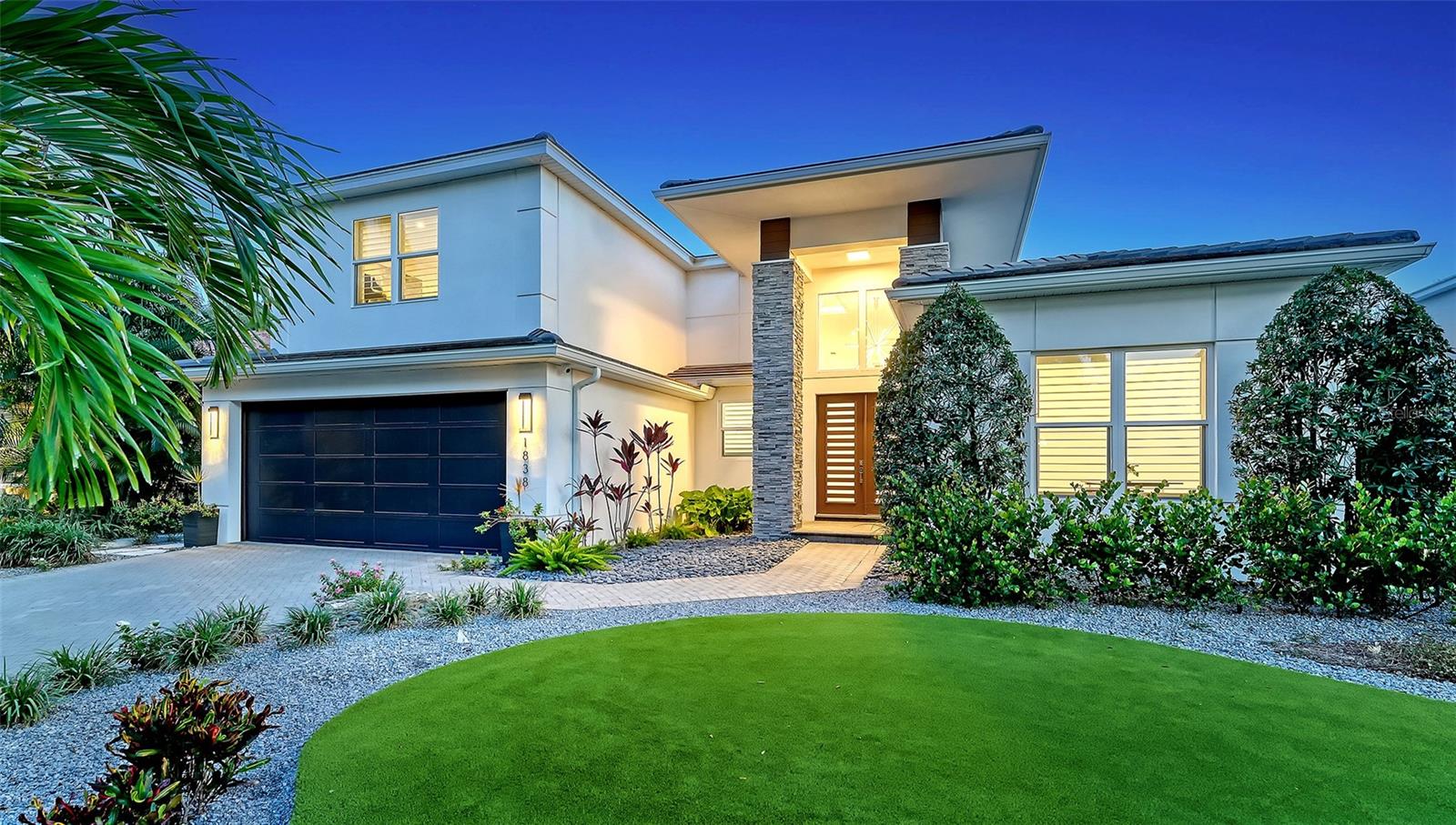 Poised on one of the prettiest tree-lined West of Trail streets, this modern coastal residence offers the ideal blend of casual elegance, thoughtful design, and everyday livability. In like-new condition and custom built in 2020 by award-winning Allegra Homes—recognized by the Building Industry Association for outstanding craftsmanship and innovative home design—this 3,220-square-foot residence with 4 bedrooms and 3 baths showcases impeccable quality and attention to detail throughout. The dramatic great room features soaring 16-foot ceilings, clerestory windows that bathe the space in natural light, designer lighting, a striking electric fireplace, and a custom entertainment wall with a stone façade and illuminated glass display shelves. Triple sliding glass doors create a seamless transition to the covered and screened lanai features a 40-foot heated saltwater pool, 2 covered seating and dining areas, a fully equipped grilling station, and convenient access to a full pool bath—creating the ultimate year-round Florida lifestyle. The culinary-influenced kitchen impresses with a professional Sub-Zero and Wolf appliance package, custom cabinetry, and a dramatic granite waterfall island with comfortable seating for 4. The full-height matching backsplash creates a stunning focal point while adding a sophisticated designer touch. The private owner's wing comes with direct lanai access, 2 customized walk-in closets, a dedicated den or home office, and the all-white bath is a refreshing oasis with its freestanding soaking tub, oversized walk-in shower, separate vanities, ample counter and cabinet space, and a water closet. A first-floor guest suite provides ideal accommodations for family and visitors, while the second level offers two additional bedrooms, a full bath, and an oversized bonus room perfect for a media room, playroom, fitness space, or additional gathering area. The home's sophisticated interior is complemented by a calming palette of whites, creams, and light-toned beiges, creating a neutral backdrop for any design style. Modern conveniences include whole-house audio with lanai speakers, a comprehensive 360-degree exterior camera system, and a low-maintenance fenced yard complete with powder-coated aluminum gates, rock walkways, artificial turf, and a private irrigation well. The striking front elevation showcases stone-wrapped columns, a brick paver driveway, and beautifully designed landscaping that creates exceptional curb appeal. You'll enjoy the convenience of walking to Southside Village with its boutique shopping, gourmet markets, acclaimed restaurants, sidewalk cafés, and vibrant local gathering spots. Downtown Sarasota, the area's renowned cultural attractions and world-famous Gulf beaches are all just minutes away. Families will appreciate the highly regarded Southside School District, known for its strong academic programs, innovative educators, and enriching arts opportunities. This exceptional residence offers the rare opportunity to enjoy luxury, comfort, and an unmatched Sarasota lifestyle in one of the city's most desirable West of Trail locations.