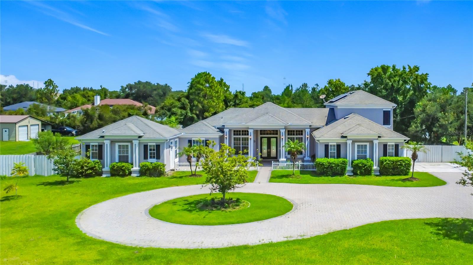 Nestled on a beautifully landscaped one-acre homesite, this stunning 6-bedroom, 5.5-bath estate offers an exceptional blend of luxury, comfort, and versatility. A circular driveway and elegant glass-inlaid French doors welcome you into 3,618 sqft of thoughtfully designed living space, complete with a private office and attached private mother-in-law suite.
At the heart of the home, the chef's kitchen is designed to impress, featuring a gas cooktop, oversized center island, breakfast bar, and an expansive walk-in pantry.
The private 1 bedroom suite offers its own living room and kitchen with 42-inch cabinetry and full-size stainless-steel appliances, providing refined accommodation for guests or multigenerational living.
The luxurious primary retreat is a true sanctuary, showcasing dual walk-in closets, separate vanities, a jetted spa tub, and a spacious walk-in shower.
The well-designed floor plan offers the convenience of primarily single-story living, with the spacious primary suite and two additional bedrooms located on the first floor. Elegant tile flooring extends throughout the entire main level, creating a seamless living environment. Upstairs, two generously sized bedrooms each feature their own private ensuite bathrooms and beautiful wood flooring, making them perfect retreats for family members or guests.
Step outside to your own private resort. The sparkling pool creates the perfect setting for relaxation and entertainment, surrounded by mature landscaping and tranquil natural beauty. Beyond the pool lies one of the property's most distinctive features—a thriving food forest offering a rare opportunity to enjoy fresh harvests from your own backyard while embracing a more sustainable lifestyle.
Tucked away within the desirable Wedgefield community, residents enjoy the serenity of estate-style living while remaining conveniently located near Orlando International Airport, major highways, shopping, dining, golf, and Central Florida's world-renowned attractions.
