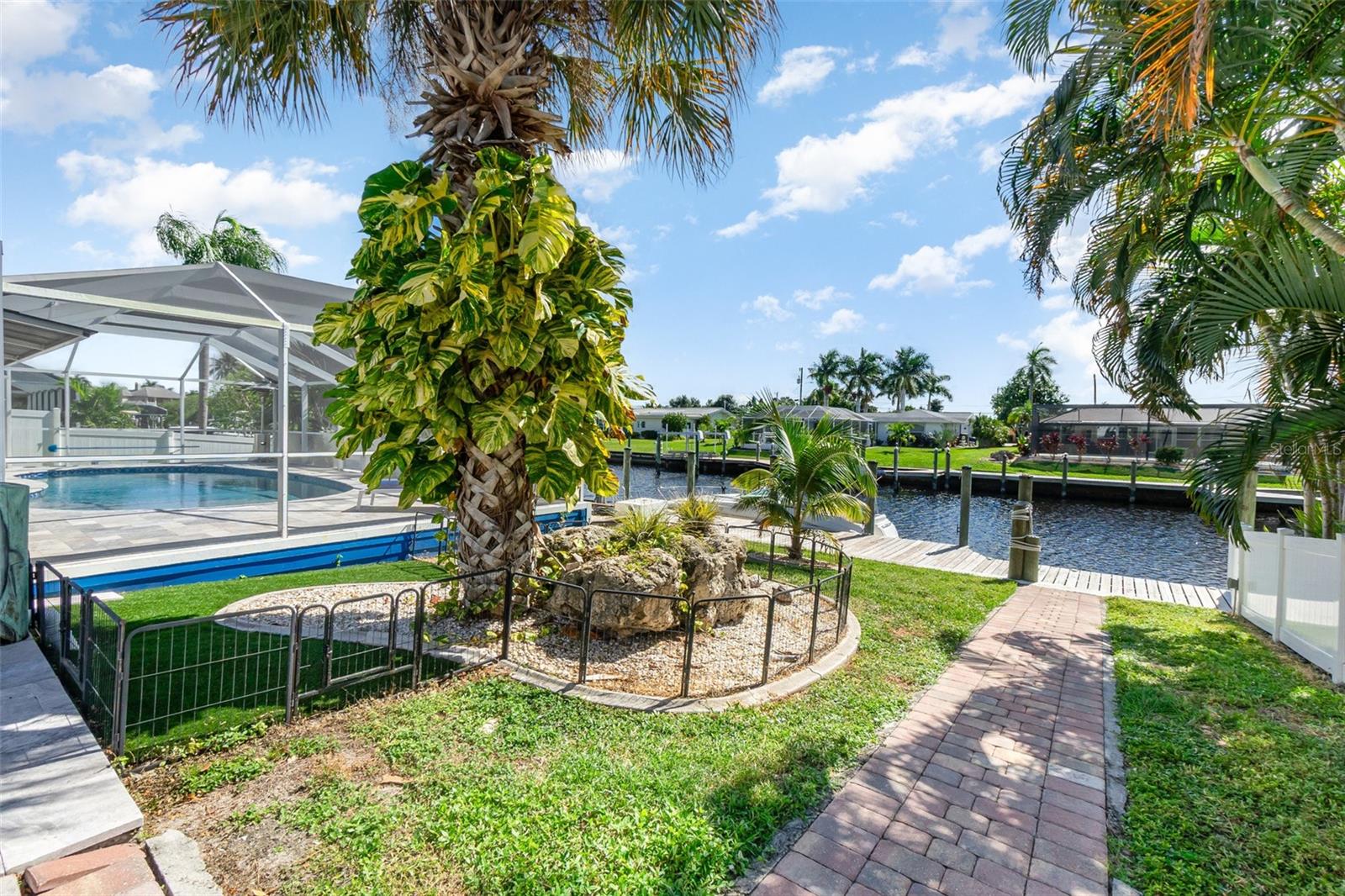 DISCOVER THE WATERFRONT LIFESTYLE YOU’VE BEEN DREAMING OF. Nestled in a classic Florida setting, this beautifully updated home is all about effortless living on the water. With direct sailboat access—no bridges, no locks—you can step onto your captain’s walk dock, lower your cantilever lift, and be on the Caloosahatchee River or out to the Gulf within minutes. A floating kayak dock makes spontaneous paddling even easier.

Inside, the home unfolds into a bright, coastal-inspired retreat where south-facing sunshine and soft breezes create a light and uplifting atmosphere. The open layout is ideal for entertaining, connecting the elegant, newly renovated kitchen to the family room and out to the pool and waterfront views beyond. The kitchen features sleek shaker cabinetry, quartz countertops, deep soft-close drawers, a stylish backsplash, and abundant storage. A spacious Butler’s Pantry—with additional cabinetry, workspace, and a wine cooler—elevates both daily living and hosting.

Wake up to water views in the generous primary suite with direct lanai access, a sophisticated ensuite bath, and a custom walk-in closet. Two additional bedrooms share an updated full bath, perfect for family or guests.

Step outside to your own private outdoor oasis. The screened lanai offers multiple areas for lounging and dining, all centered around the 2020 remodeled saltwater pool featuring a sun shelf, resurfaced interior, and travertine paver deck. Whether you’re relaxing poolside, enjoying sunset drinks on the dock, or heading out for a day on the water, this home encourages a lifestyle rooted in relaxation, recreation, and connection to nature.

Additional perks include a 2020 metal roof, 2020 AC, cedar outdoor ceilings, 2020 double-pane windows and doors, new blinds, a 50-amp RV hookup, fresh interior/exterior paint, a fenced yard with dual gates, and Kevlar hurricane panels for full-home protection.

Located in peaceful Waterway Estates, a boating and lifestyle-friendly community with no HOA, this property is perfect for full-time living, a vacation getaway, or an income-producing investment. Close to beaches, shopping, dining, golf, and all the outdoor adventures southwest Florida offers, this one-of-a-kind home lets you live every day like you’re on vacation.

(Note: Bonus room referenced in listing is the Butler’s Pantry.)