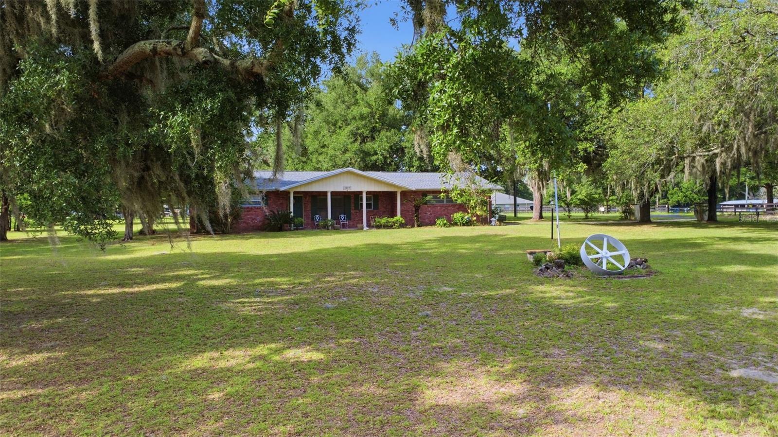 Welcome to Green Turf Acres, where country living meets everyday convenience in the heart of Ocala, the Horse Capital of the World. Situated on a beautiful 2.16-acre corner lot, this spacious 4-bedroom, 2-bath home offers 1,634 square feet of living space and endless possibilities for those seeking room to spread out and enjoy a rural lifestyle.

The home features a desirable split-bedroom floor plan, tile flooring, ceiling fans throughout, central heating and air conditioning, and a spacious 2-car garage. Recent updates include a new roof installed in October 2023, a tankless water heater, and included washer, dryer, refrigerator, and freezer. One of the bedrooms offers a private exterior entrance, making it ideal for a home office, guest suite, or flex space.

Step outside and enjoy the property's natural beauty with mature oak trees, grapevines, fig and sour orange trees, and plenty of open space for gardening, recreation, horses, or other farm animals. Additional features include a private well, septic system, wood fencing, and a sprinkler system.

Enjoy the peace and privacy of country living while remaining just minutes from shopping, dining, schools, healthcare facilities, and major roadways including I-75. Conveniently located near the VA Medical Center and Ocala International Airport, this property offers the perfect balance of acreage, functionality, and accessibility.

Whether you're looking for a mini-farm, a family homestead, or simply more space to enjoy the outdoors, this unique Ocala property is full of opportunity and ready to welcome its next owner.