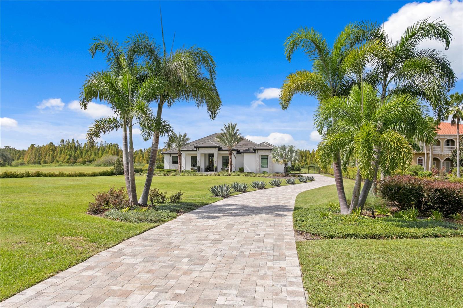 Nestled behind the gates of the coveted Stonelake Ranch community, this extraordinary custom residence sits on nearly 2 acres backing to a protected bird preserve and canal connecting to the largest lake in Hillsborough County. The crown jewel is the nearly $1 million Ryan Hughes Design outdoor living space — an infinity-edge pool, jetted hot tub with waterfall edge and loungers, swim-up bar, sunken lounge, water ledge with built-in umbrellas and fire feature, water feature wall, separate fire pit and seating, a fully appointed outdoor kitchen and dining pavilion, and an outdoor media area — all set against the serene backdrop of the preserve.  From the moment you turn down the long, palm-lined driveway — flanked by grand mature Royal Palms — you sense this home is something entirely different. An 18-foot porch ceiling announces the scale and craftsmanship within, drawing you into a soaring foyer that opens to the formal living and dining room — an entertainer's dream anchored by a gas fireplace, custom Henge lighting, and a wall of glass that frames the resort-style pool beyond. A walk-in refrigerated wine room by Cavà Vin completes the picture.

The thoughtfully designed split floor plan places the private primary suite and study on one wing, while the family room, game room, and guest suites anchor the other. The primary retreat features tray ceilings with cove lighting, a sitting area, pool-side sliders, dual custom closets, and a spa-caliber bath with floating soaking tub, artisan marble tile, walk-in shower, and a vanity crafted by Busby Cabinets — who also designed every cabinet throughout the home.

The chef's kitchen is equally appointed: Wolf gas cooktop, double Wolf ovens, Sub-Zero refrigerator, Scotsman nugget ice machine, a generous island, large walk-in pantry, and an eat-in nook overlooking the family room. Designer lighting by Ochre, McEwen, and Palachek elevates every space throughout.

For the most discerning buyer, this is the one.