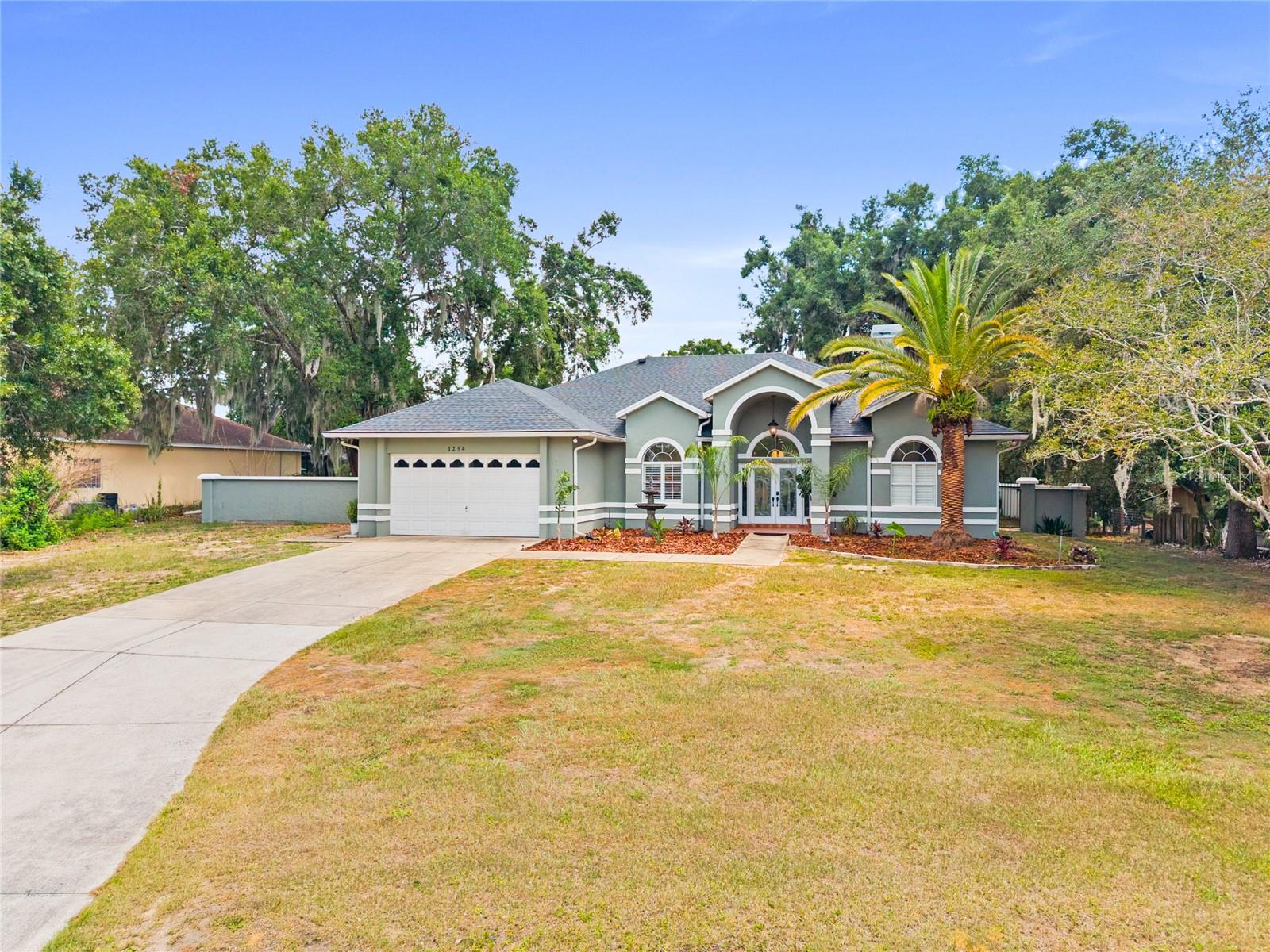 If you ever dreamed of owning your own private tropical paradise only one block from Lake Eustis, here it is. Only 1.2 miles from the boat ramp and Nestled on almost one acre, this beautifully updated and meticulously maintained 3-bedroom, 2-bath home offers 1,932 square feet of exceptional Florida living on a huge (and possibly separatable lot). This .84 Acre property is tucked away on a quiet cul-de-sac with no through traffic, this exceptional property offers privacy, tranquility, and endless possibilities.
Designed for both everyday living and entertaining, the open floor plan features engineered hardwood floors, beautiful wood burning fireplace and stacking sliding glass doors that create a breathtaking first impression, making it feel as though you're walking directly into your own lush tropical pool oasis the moment you enter the home. The seamless connection between the indoor living spaces and the outdoors fills the home with natural light and creates the perfect setting for entertaining or simply enjoying Florida living. 
Step outside to your private retreat with a screen-enclosed saltwater pool surrounded by lush tropical landscaping, mature fruit trees, and expansive green space. The beautifully cleared and leveled rear portion of the property creates even more usable outdoor living space while preserving the peaceful, park-like setting.
The oversized lot offers exceptional flexibility with a large private RV pad situated on its own dedicated area behind the home, two storage sheds, and abundant room for an in-law suite, guest house, workshop, man cave, she shed, additional garage, or simply space to garden, play, and enjoy your own private sanctuary. Subject to buyer verification with local zoning and subdivision requirements, the property may also offer the potential to create a separate buildable lot—an exciting opportunity for future investment or multigenerational living.

This home has been thoughtfully updated throughout. In 2025, a new roof with transferable warranty was installed, along with a new water heater, fresh interior and exterior paint, decorative moldings throughout the home, an upgraded four-zone irrigation system, new door hardware, and updated light fixtures. The beautifully renovated guest bathroom features elegant Carrara marble flooring and countertop, a ceramic tile shower, and all new fixtures. 
Additional improvements include a new drainfield (2021), a new pool pump and saltwater pool system (2026), a stylish ceramic tile kitchen backsplash (2026), and the rear of the property professionally cleared and leveled (2026), further enhancing the functionality of this remarkable homesite.
The tropical landscape is enhanced by beautiful citrus and fruit trees, including mature avocado and mango trees, creating a backyard that is as productive as it is beautiful.
Ideally located just minutes from the charming shops, restaurants, waterfront, and year-round festivals of Mount Dora, and approximately one hour from both Orlando and Florida's world-famous beaches, this home offers the perfect combination of peaceful country-style living and everyday convenience.
Properties offering this much land, privacy, extensive updates, and future potential rarely become available. Don't miss this unique opportunity to own one of Eustis' most exceptional homes.