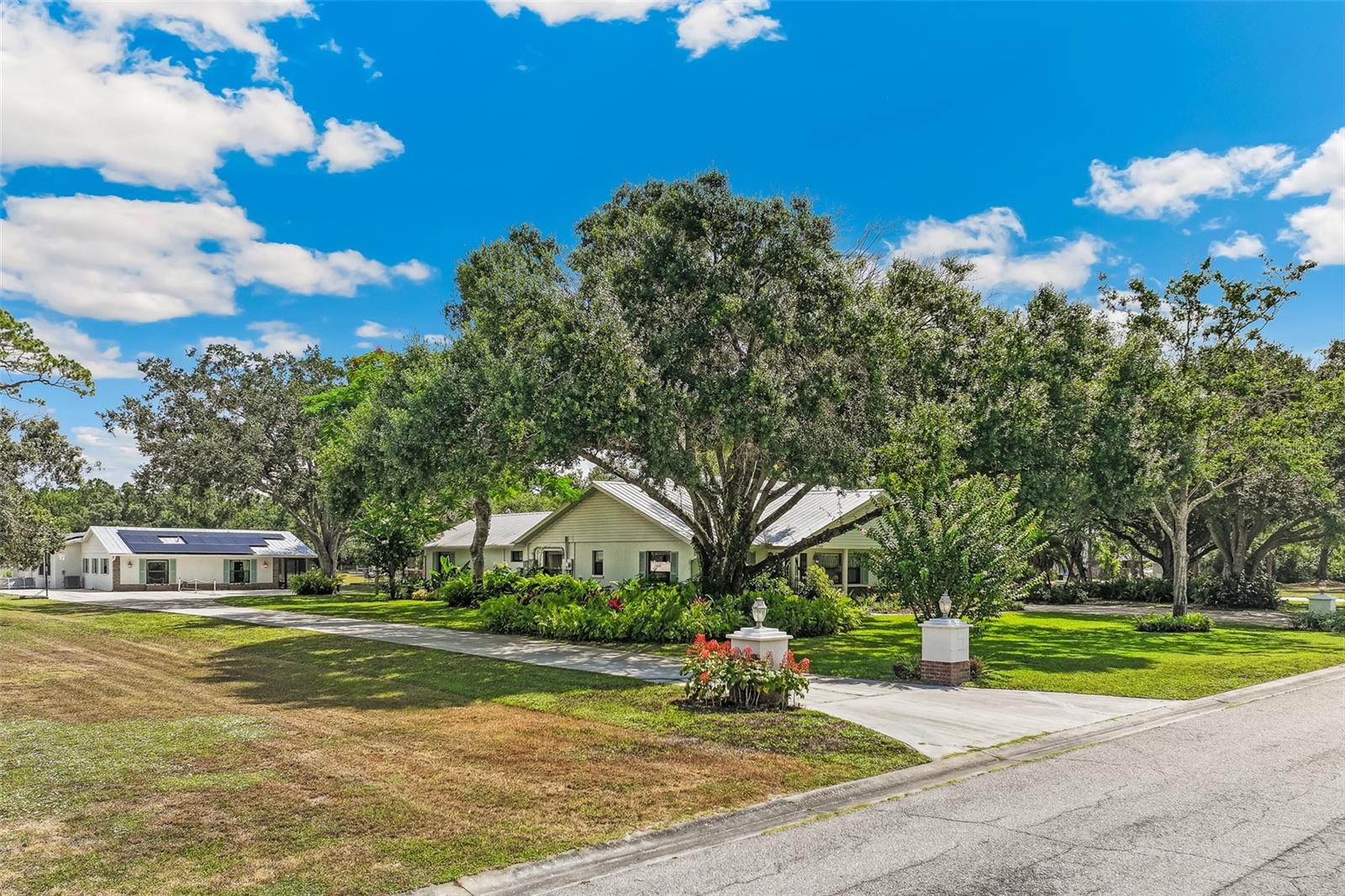 A truly rare opportunity in Sarasota! Nestled on 2 private acres in Racimo Ranches, this unique property features TWO separate single-family homes, offering endless possibilities for multigenerational living, guest accommodations, or rental income.
The main residence offers 3,179 square feet of thoughtfully designed living space with 3 bedrooms, 3.5 baths, and a 2-car garage. Inside, you'll find luxury vinyl plank flooring throughout, crown molding, and a living room anchored by a cozy fireplace with custom built-in shelving. The spacious family room offers exceptional flexibility, making it ideal for a media room or multipurpose living space, complete with a built-in desk area and cabinetry. The kitchen features Corian countertops, bar seating, and easy access to the separate dining room, making entertaining a breeze. The split-bedroom floor plan offers privacy, with the primary suite tucked away on one side of the home, while the opposite wing features a guest bedroom with its own en-suite bath and an additional bedroom conveniently located near a full hall bathroom. Improvements include a metal roof (2021) and HVAC (2022).
The second residence offers 1,473 square feet of comfortable living space with 2 bedrooms, 2 baths, a 1-car garage with laundry room, and its own private concrete driveway, adding convenience and independence. The living area features luxury vinyl flooring throughout, built-in shelving in the spacious family room, granite countertops in the kitchen, and a relaxing sunroom (20’x23’) overlooking the beautiful grounds. Improvements include a metal roof (2021) and HVAC (2024).
Step outside and experience your own tropical retreat. Lush landscaping, mature plantings, flowering garden beds (5 rows of raised beds-4’x70’), lawn and garden bed irrigation, a deck with sandbox, and peaceful outdoor spaces create an inviting backyard oasis perfect for relaxing, gardening, or gathering with family and friends.
Additional improvements include a new well installed in 2023 and fully paid-off solar panels installed in 2022, helping keep electric costs low while improving efficiency for both homes.
Properties offering two homes on acreage in Sarasota with this much space, flexibility, and privacy are hard to find. Enjoy country-style living with room to spread out while remaining conveniently close to everything Sarasota has to offer.