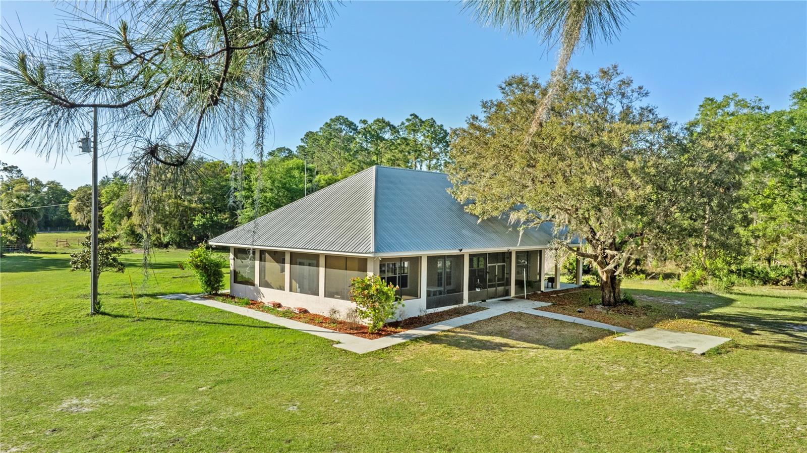 REDUCED! SELLER MOTIVATED!! Once a boys & girls summer horse camp in the early 1940s is now a rare 10 acre horse hobby farm located on an expansive 85 acres lake. The unique property combines old Fl charm with unlimited potential for farming, recreational use, horses, rental income (has RV pad with septic, bath/laundry bldg) and is currently rented. Primary home is lakefront and has 2130 sq ft of wrap around porches. Small log cabin with gorgeous stone fireplace, 1 bedroom, 1 bath, kitchen, living room, office, & screened front porch, is at the entrance to the property and has been completely renovated. It has rental potential (with no restrictions) or could be used for family or guests. 
Massive aluminum carport has work space and is detached. 1 barn can be used for equipment, storage or convert to a workshop. There are 4 stalls, 5 grazing pastures, run-in shed, no climb fencing, and a chicken coop. 
Nestled in rural Volusia Co FL, its a quick drive to the worlds most popular beach, Daytona Beach in approximately 40 mins; Ormond Beach in 10 mins; boating on the St Johns River or Lake George is 10-15 mins away. Visit the popular and beautiful springs DeLeon Springs and Silver Springs in about 15-30 mins.  Go Hiking and camping in the Ocala National Forest, 20 min drive. The Worlds largest Equestrian Center in Ocala FL is approximately a 60 min drive. Property is also about 15 mins from the Fairgrounds and race track.
