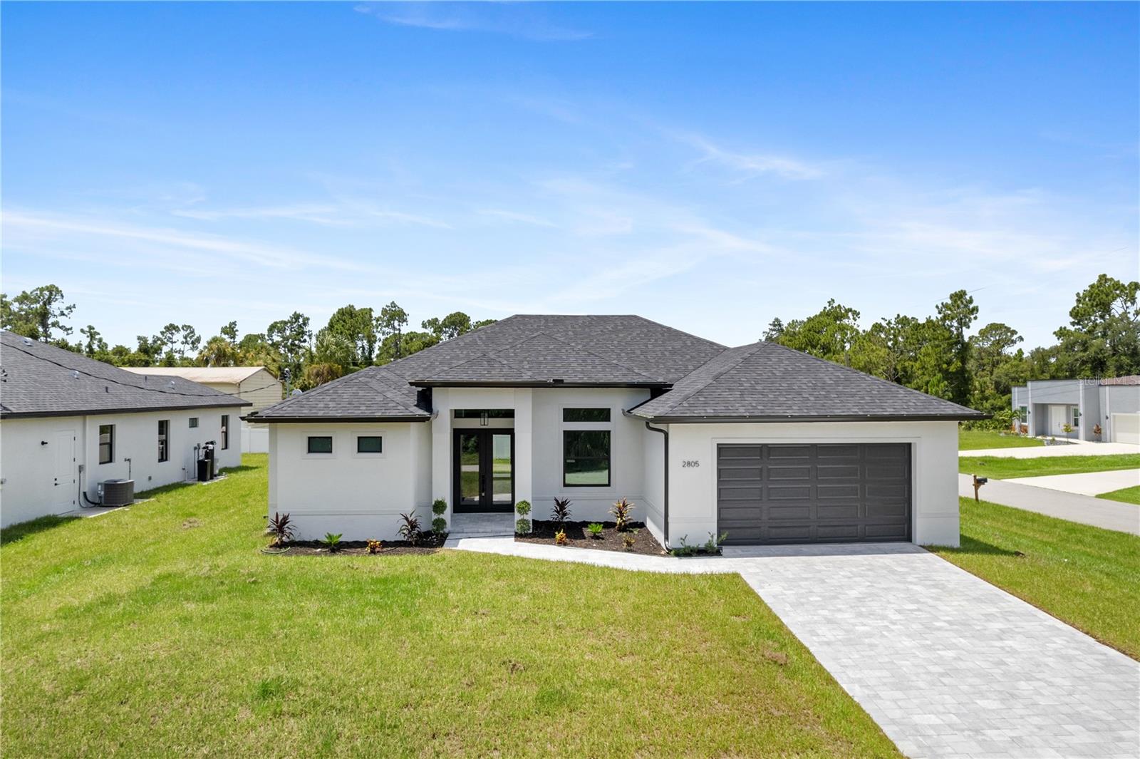 MOVE-IN READY NEW CONSTRUCTION  This home features a CORNER LOT offering rare kind of space which allows for Room for the Pool.  Also features full hurricane-IMPACT WINDOWS and DOORS, an extended oversized garage, and spacious covered lanai already pre-plumbed for your future outdoor kitchen.  Offering 3 bedrooms, 2 bathrooms, plus a Flexible Den that can easily function as a 4th bedroom / office, or additional living space, the layout is designed for modern living. As you step inside, you’re welcomed by soaring tray ceilings and expansive 3 panel sliding glass doors that seamlessly connect the interior to the oversized lanai and private backyard — creating an exceptional indoor-outdoor living experience.    At the center of the home is a beautifully appointed chef’s kitchen featuring an impressive 10-foot quartz island, upgraded LG stainless steel appliances, abundant cabinetry perfect for entertaining or everyday comfort.    The primary suite is a private retreat complete with tray ceilings, a generous walk-in closets, and a spa-inspired bathroom showcasing DUAL SHOWERS and VANITIES, oversized walk-in showers with glass enclosures, and an expanded layout designed for convenience and relaxation.    Premium Upgrades Include:  Full hurricane-impact windows and doors Paver driveway with upgraded landscaping Waterfall Kitchen Island  Large covered lanai pre-plumbed for outdoor kitchen  Extended oversized garage ideal for larger vehicles or trucks  Recessed A/C system in garage for climate-controlled storage  Luxury LVP flooring throughout  Glass French doors in the den  Laundry room with built-in shelving  Upgraded elongated toilets and Moen Genta fixtures  Nest WiFi smart thermostat for remote climate control, NON Flood Zone lot for added peace of mind.