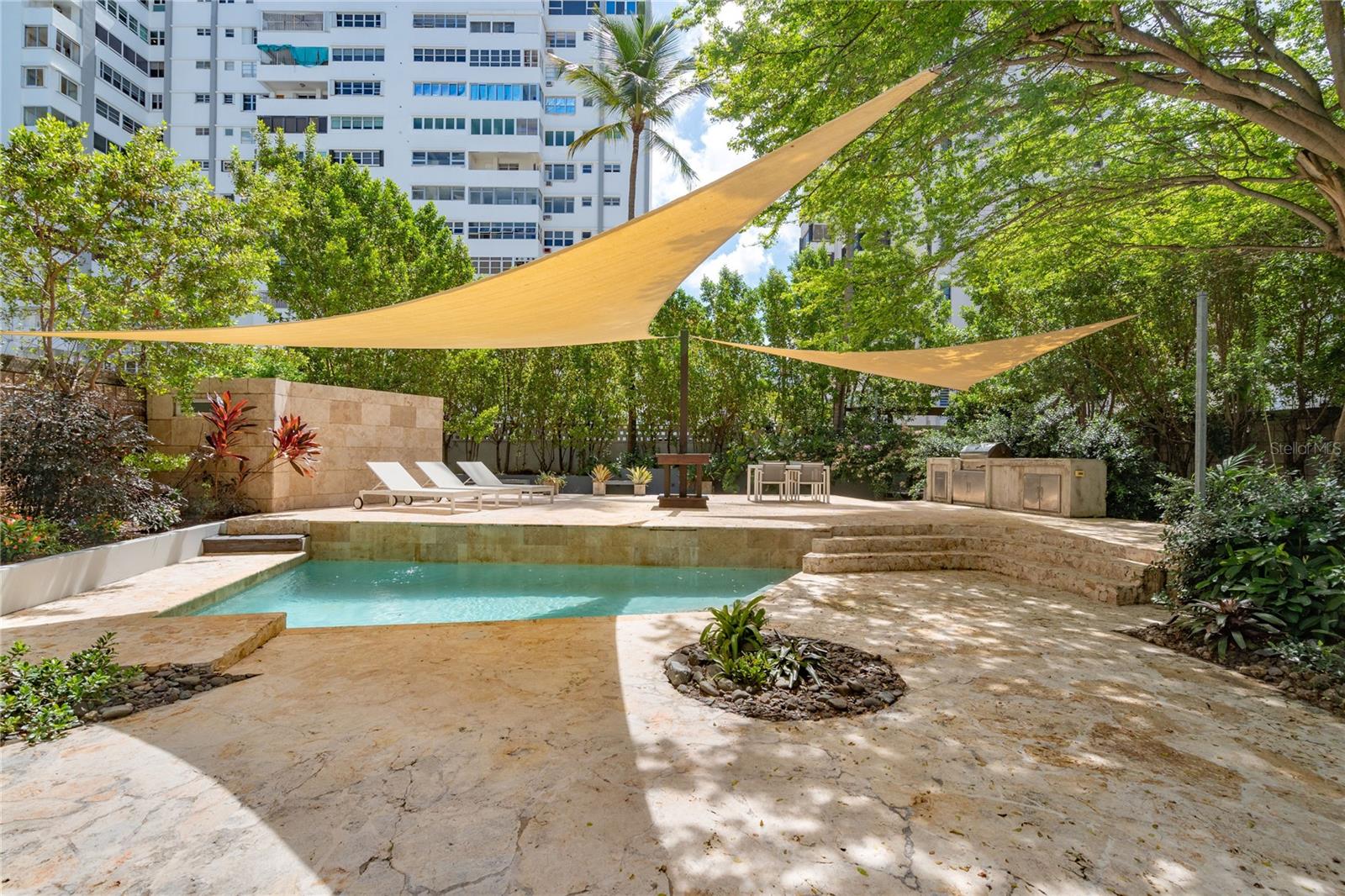 Tucked away on the quiet street, Rodriguez Serra, this mid-century modern home offers a rare blend of privacy, space, and convenience. Ideally located just three blocks from St. John’s and Robinson Schools, one block from the beach, and near top restaurants, cafés, grocery stores, and pharmacies, this property places the best of Condado right at your doorstep.

Step inside to a bright, open floor plan filled with natural light and timeless terrazzo floors. The first level features a welcoming foyer, spacious living and dining areas, and a kitchen that flows seamlessly into an exceptional private outdoor retreat.

Designed for both relaxation and entertaining, the outdoor space boasts lush landscaping, a swimming pool, BBQ area, wooden deck, outdoor shower, and abundant shade from surrounding trees and flowers.

Also on the first level is a versatile fourth bedroom with private bath, a laundry room, utility room, and convenient side entrance.

Upstairs, the primary suite includes an en-suite bathroom and walk-in closet, complemented by two additional bedrooms, each with their own en-suite bath. All three bedrooms open onto a 640 sq. ft. balcony overlooking the pool and gardens—a perfect spot to enjoy morning coffee or evening breezes.

Offering a spacious yet comfortable layout and an unmatched outdoor lifestyle, this property is a rare opportunity to own a private home in the coveted Condado neighborhood.