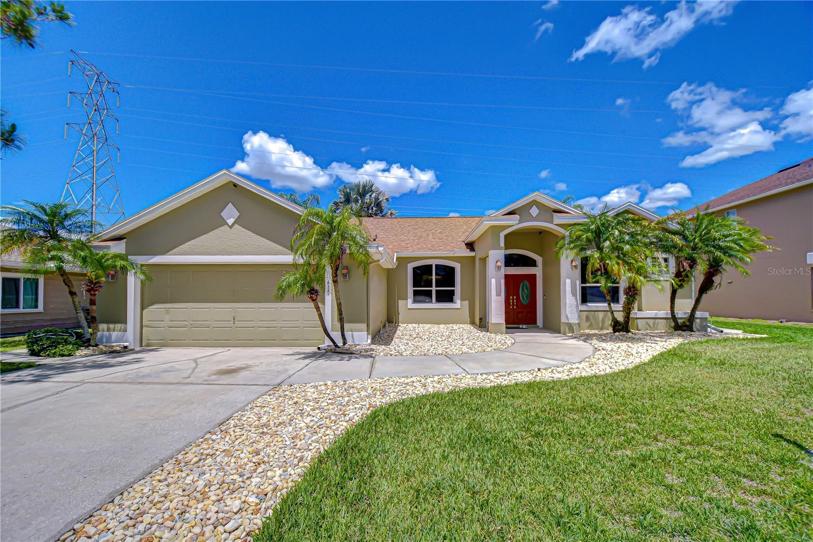Tucked inside a quiet cul-de-sac where morning walks meet shimmering water views and golf course greens stretch beyond your backyard, this Northdale Golf Club pool home feels like a private retreat—yet lives like a gathering space.
Perfectly positioned with a scenic walkway, tranquil pond, and two tees just beyond the fully fenced yard, this 3-bedroom, 2-bath residence with a dedicated office/playroom and 2-car garage spans 2,110 sq ft of thoughtfully designed living space, where indoor comfort and outdoor beauty blend effortlessly. The 2-car garage is equipped with a 50-amp, 240V industrial-grade NEMA 14-50 outlet, EV-ready for convenient at-home charging. From the moment you arrive, the curb appeal makes a striking first impression. A paved driveway and gracefully curved walkway meander through beds of large stone river rock, contrasted by swaying palms rising from the manicured lawn, guiding you to a columned portico. Double front doors, with elegant oval glass inserts and a transom window above, create a grand yet welcoming entrance. Step inside to a soaring, light-filled foyer where openness and light draw you in.
To the left, the dining room invites memorable dinners, while straight ahead, the spacious living room showcases triple sliding glass doors framing the pool and bringing in light. Architectural details—rounded corners, graceful archways, recessed lighting, and smooth ceilings—create a refined yet relaxed aesthetic throughout. Set apart for privacy, the primary suite is a true retreat. Double doors—crowned by a recessed display niche—open to an inviting entry with an art niche, guiding you into the suite, while a separate hallway leads to the ensuite bath. The bedroom offers private access to the lanai and dual closets, including a walk-in with custom built-ins. The ensuite bath delivers a spa-like experience with a double vanity featuring undermount sinks, ample drawer and cabinet storage, a soaking tub set on a tiled platform framed by a large window, and a distinctive glass side window offering a subtle peek into the tiled walk-in shower. A private water closet adds comfort and convenience. At the heart of the home, the kitchen blends functionality with charm, featuring ample cabinetry with decorative plant shelves above, a built-in pantry, and a peninsula breakfast bar perfect for casual mornings or evening conversations. The adjacent café area, wrapped in tall angled windows, offers picturesque pool views, while a French door connects indoor dining to outdoor living. Just beyond the breakfast bar, the family room is highlighted by tall curved windows and sliding glass doors that open to the lanai and pool area, creating an easy flow for everyday living and entertaining. Beyond this space, the flexible office or playroom adapts to your needs—whether working from home, creating, or relaxing. The split floor plan provides privacy, with generously sized secondary bedrooms featuring ample closets and ceiling fans, along with a well-appointed guest bath. Step outside to see what makes this home unforgettable. A paver deck surrounds the saltwater free-form pool, complete with a sun shelf and bubblers that shimmer in sunlight. The screened enclosure offers year-round enjoyment, while two gated entries lead to a lush fenced backyard opening to sweeping golf course views and peaceful pond beyond—your own slice of serenity. Schedule your showing today and explore the possibilities.