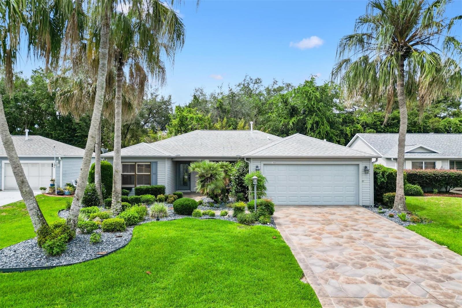 At the heart of a lush tropical garden accented by a cascading waterfall, this residence offers a serene escape within The Villages. This 3BR/2BA single-family home approximately 1,808 SF of living space built in 2000 features cathedral ceilings, recessed lighting, and solar tubes enhancing natural light throughout. The chef-style kitchen offers custom cabinetry adjacent to an open floor plan that flows into a great room framed by windows overlooking the garden and waterfall. The primary bedroom includes dual closets and an updated bath. New Mohawk designer flooring spans the home, complemented by an indoor laundry room and a large screened birdcage. Additional practical features include a spacious 2-car garage with attic storage, a new roof installed in 2022, and a new AC system in 2023. Situated with convenient access to reputable schools, diverse shopping centers including Publix and Walmart, and prominent healthcare facilities like UF Health The Villages Hospital, the location balances tranquility with essential amenities. Bond to be paid by Seller at closing