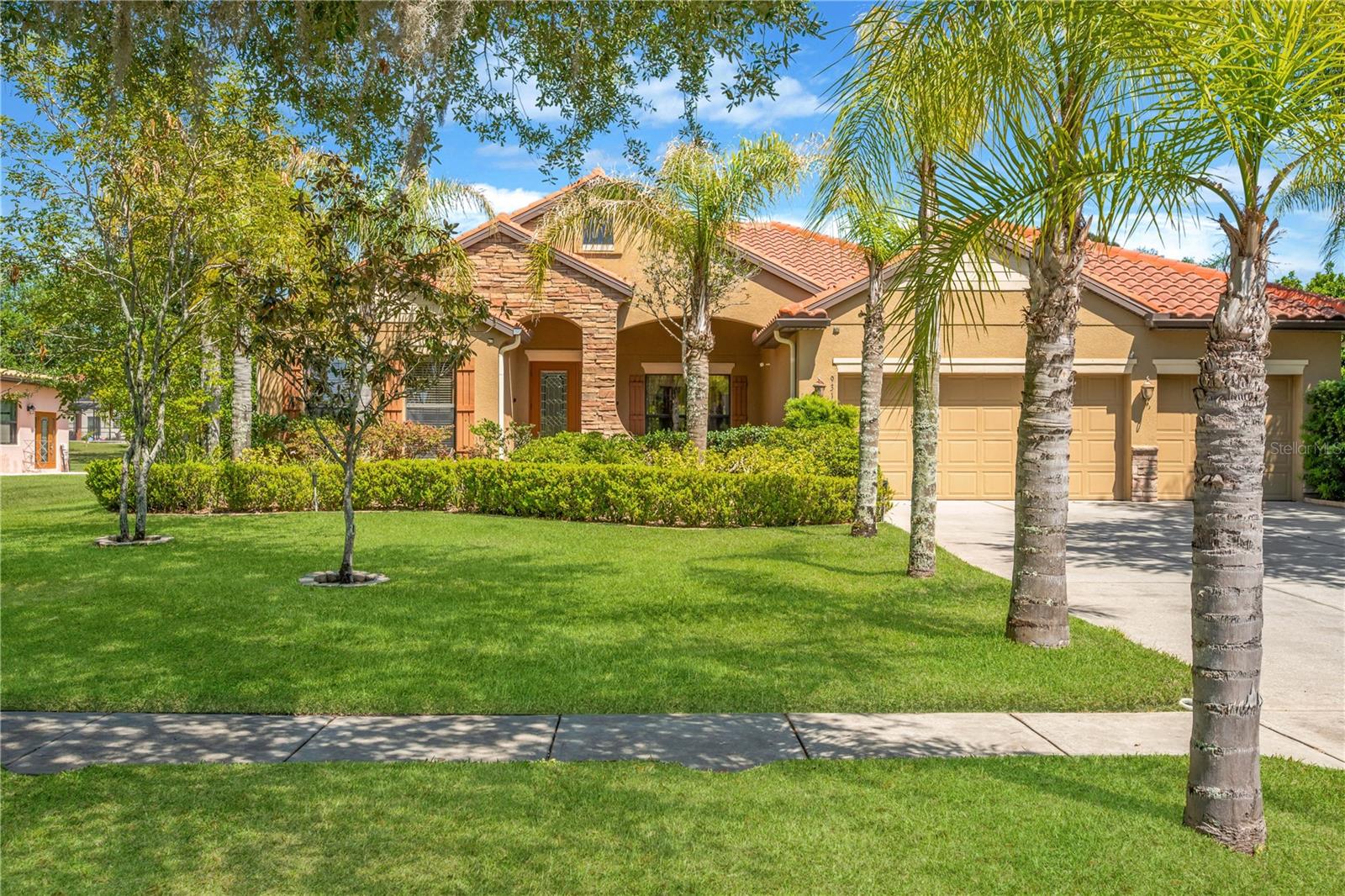 One or more photo(s) has been virtually staged. BUYER GOT COLD FEET-BACK ON MARKET 5/24! Welcome to the exclusive gated community of Toulon, where elegance, privacy, and convenience come together in this stunning 5-bedroom, 3-bath, 3-car garage home situated on a sprawling half-acre lot. Impeccably maintained and rich in curb appeal, this residence welcomes you with a professionally landscaped yard, classic Spanish tile roof and stone accents, and a beautiful leaded glass front door with sidelight.
Step inside to discover a bright, open floor plan designed for both everyday living and effortless entertaining. Large-format ceramic tile flows throughout the main living areas, while rich hardwood flooring adds warmth and character to the bedrooms. Sunlight pours through the home, highlighting spacious rooms and elegant finishes throughout.
At the heart of the home is a gourmet kitchen sure to impress, featuring stone countertops, abundant cabinetry, a large center island, breakfast bar seating, and a walk-in pantry to keep everything organized. Whether hosting holiday gatherings or enjoying quiet mornings at home, this kitchen is built for connection.
Multiple living spaces offer flexibility for every lifestyle, including a formal living room/dining room for entertaining guests and a cozy family room perfect for movie nights or relaxing evenings.
The luxurious primary suite is a private retreat, complete with dual walk-in closets and a spa-inspired bath featuring dual sinks, a garden tub, and a separate walk-in shower. Additional bedrooms are generously sized and ideal for family, guests, or home office space.
Step outside and embrace Florida living at its finest on the screened and covered lanai, overlooking an expansive park-like backyard with endless possibilities—room for a future pool, outdoor kitchen, playground, or simply enjoying peaceful privacy under the open sky.
Additional highlights include a 3-car garage, irrigation system powered by a private well, sidewalks throughout the neighborhood, and an A/C system replaced in 2020 for added peace of mind.
Exceptional convenience and proximity to shopping, dining, and everyday essentials, this property perfectly blends peaceful living with easy accessibility.  Close to major highways (3 miles to I-75 and 4 miles to I-4) making commuting and travel quick and effortless. Mac Dill Air Force Base, Moffit Medical Center and University of Southern Florida are easy commutes. Disney is an hour away!  NO CDD fees and low HOA dues. Don’t miss the rare opportunity to own an oversized lot in this highly sought-after area!