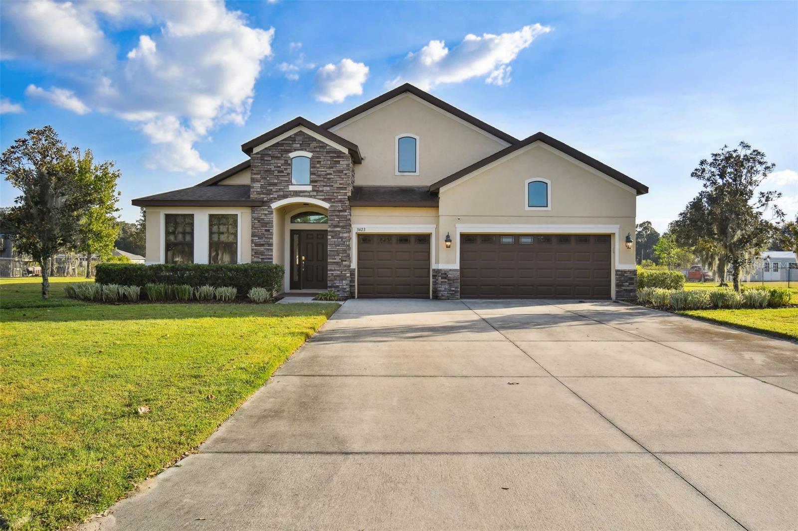 Nestled in the heart of Wiggins Estates, this meticulously crafted Inland Home is a beacon of sophistication and convenience in a country setting. Graciously situated on an impressive 1.02-acre lot, this upgraded residence offers not just a home but an extraordinary lifestyle. With conservation wetlands and an accessible fishing pond behind, your surroundings provide a panoramic vista of natural beauty. Inside, discover a spacious haven featuring four generously-sized bedrooms and three full bathrooms. The expansive living areas are adorned with breathtaking flooring, and the kitchen is a masterpiece of upgrades. An additional office space, a three-car garage, and an expansive extended screened lanai await your enjoyment. Bask in the elegance of soaring vaulted ceilings and abundant natural light that permeates every corner of this home. The heart of this residence is the chef's kitchen—an inviting space that boasts a center island, a luxurious dining area with custom stone accents perfect for entertaining guests, granite countertops, stainless steel appliances, and tall cabinets, ensuring storage space is never a concern. Your luxurious master suite is a sanctuary featuring large windows, a capacious walk-in closet, and a master bath complete with a garden tub and dual sinks. Every bathroom is adorned with granite counters and upgraded lights and mirrors. Each room is embellished with upgraded light fixtures and ceiling fans, complementing the delightful Florida climate. Step outside onto your extended lanai after a long day and soak in a sunset on your patio swing with unobstructed views. Alternatively, enjoy the crisp winter air by sitting outside by your fire pit. The patio and fire pit provide the perfect setting for relaxation and outdoor enjoyment. Conveniently located between Trapnell Road and Sparkman Road in Plant City, this neighborhood offers easy access to Lakeland, Tampa, and downtown Plant City. The time has come to make this wonderful home yours—schedule your appointment today!