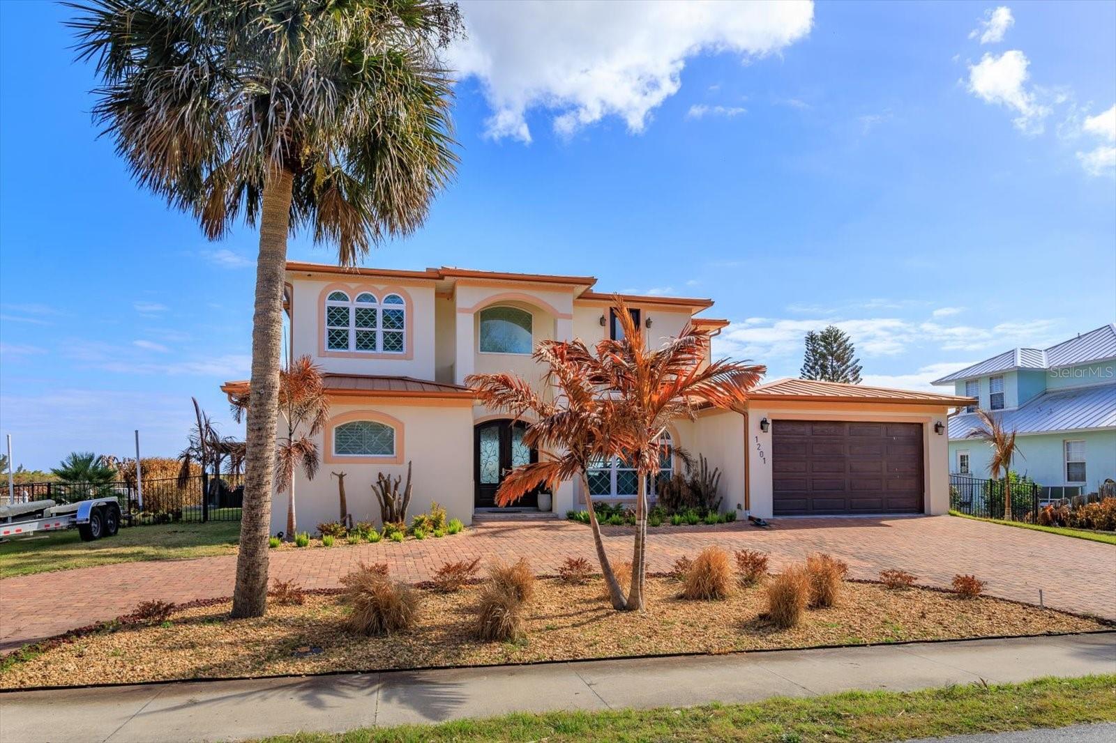 Stunning custom 2020 riverfront home offering direct access to the Intracoastal Waterway with dockage of a 15,000 lb boat lift. Ideally located in the heart of Edgewater and just 10 minutes to New Smyrna Beach.  This 4 bed, 3.5 bath residence delivers luxury waterfront living with no HOA.
The open concept interior showcases a dramatic abalone feature wall, floor to ceiling glass doors, and elegant coffered ceilings.  The gourmet kitchen features a spacious walk in pantry, quartz breakfast bar, natural gas stove, and premium cabinetry with crown molding - all overlooking serene water views. Built for peace of mind with hurricane rated windows/doors, metal roofing, and a tankless water heater.
The downstairs primary suite offers breathtaking water view and a spa style bath with soaking tub and steam shower.  Upstairs, a large family/game room anchors three guest bedrooms, two with access to a shared waterfront balcony perfect for sunrise views.
Outdoor living shines with a heated saltwater pool, charming gazebo, and a private path leading to the covered dock.  Quick access to the Inlet (approx. 7 miles) makes boating, fishing, and exploring the lagoon effortless.  Side yard accommodates boat trailer parking.  Short term rentals allowed, offering excellent flexibility.
A rare opportunity to own a modern, move in ready waterfront retreat where every day feels like a vacation.