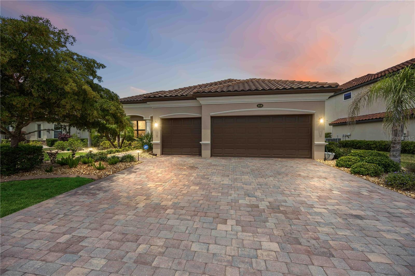 4 BEDROOM, WATERFRONT HOME IN GATED COMMUNITY/WELLEN PARK: Why wait to build a home when the perfect, luxurious home is ready for you now? With a full 4 bedrooms (one can serve as a great home office) a “split” bedroom plan (privacy for all), 2 ½ bathrooms, an open floor plan & a beautiful brick paver lanai with heated pool and spa overlooking a picturesque pond– it’s ready for you right now! This Oakmont floor plan home greets you with an elegant paver driveway & walkway, luscious landscaping with stone, concrete curbing & lighting up to a grand, double pillar entry. Stepping inside, the spacious living room & dining room features over 10' ceilings (with 8' doors throughout the house), elevated crown molding, 5 1/4' baseboards, rounded corners, and a stunning view of your private backyard oasis overlooking the tranquil water. The designer-forward kitchen boasts 42" wood cabinetry, pull-out drawers, under cabinet lighting, granite countertops with tile backsplash, quality stainless steel appliances, and ample seating at the bar and dinette areas--this all overlooks the amazing views through the sliding glass doors–leading to the large, covered lanai (22’ x 11’), & an expansive screened area with your pebble tech, electric heated pool and spa with water feature all with beautiful paver flooring, ample space for lounging and gathering with guests–all overlooking the calming water views, affording you the ultimate in privacy! Truly, your own personal “retreat”! There is plenty of room inside with the "split" bedrooms, the owner’s suite is separate offering a spacious bedroom, a doors leading to the lanai & pool area, spacious walk-in closet with custom built-ins to maximize space & large spa-like ensuite bathroom combination. You’ll enjoy the comfort of dual split sinks, granite countertops & wood cabinets, a private water closet, soaking tub with separate shower, and a linen closet. The 2nd bedroom has a roomy double closet & ceiling fan--the 3rd bedroom has a half bath that leads out to the pool for ease of access. The 4th bedroom offers a great flex space with french doors & large closet that can used as an office, den, or bedroom. A separate laundry room with quality washer & dryer just 3 years old, complete w/cabinets, sink & access to the with a full 3-car garage with epoxy coated floor, utility sink, & working area with built-in cabinets for storage and countertop space. Additional features of this home include: complete hurricane protection plus an electric hurricane shutter for the lanai, the exterior of the home was painted 4 years ago, automatic underground landscape lighting in the front & backyards, and the added bonus of being in an "X" flood zone. This home is offered partially furnished–perfect for an easy "move in"--come enjoy our balmy Florida winters! Additionally, you’ll have the luxury of enjoying the AMAZING community of Gran Paradiso complete w/ world-class resort center & clubhouse w/ a resort pool, fitness center, saunas, tennis & pickleball courts, and SO much more! With a variety of classes & activities all within the community, you'll never want to leave. All this & you are right next door to Wellen Park Downtown complete w/a wide variety of casual & upscale dining venues, shopping, Farmer’s markets, concerts, walking & biking trails. Close to world-class Gulf beaches, boating & fishing, as well as numerous golf courses! Don’t wait…
