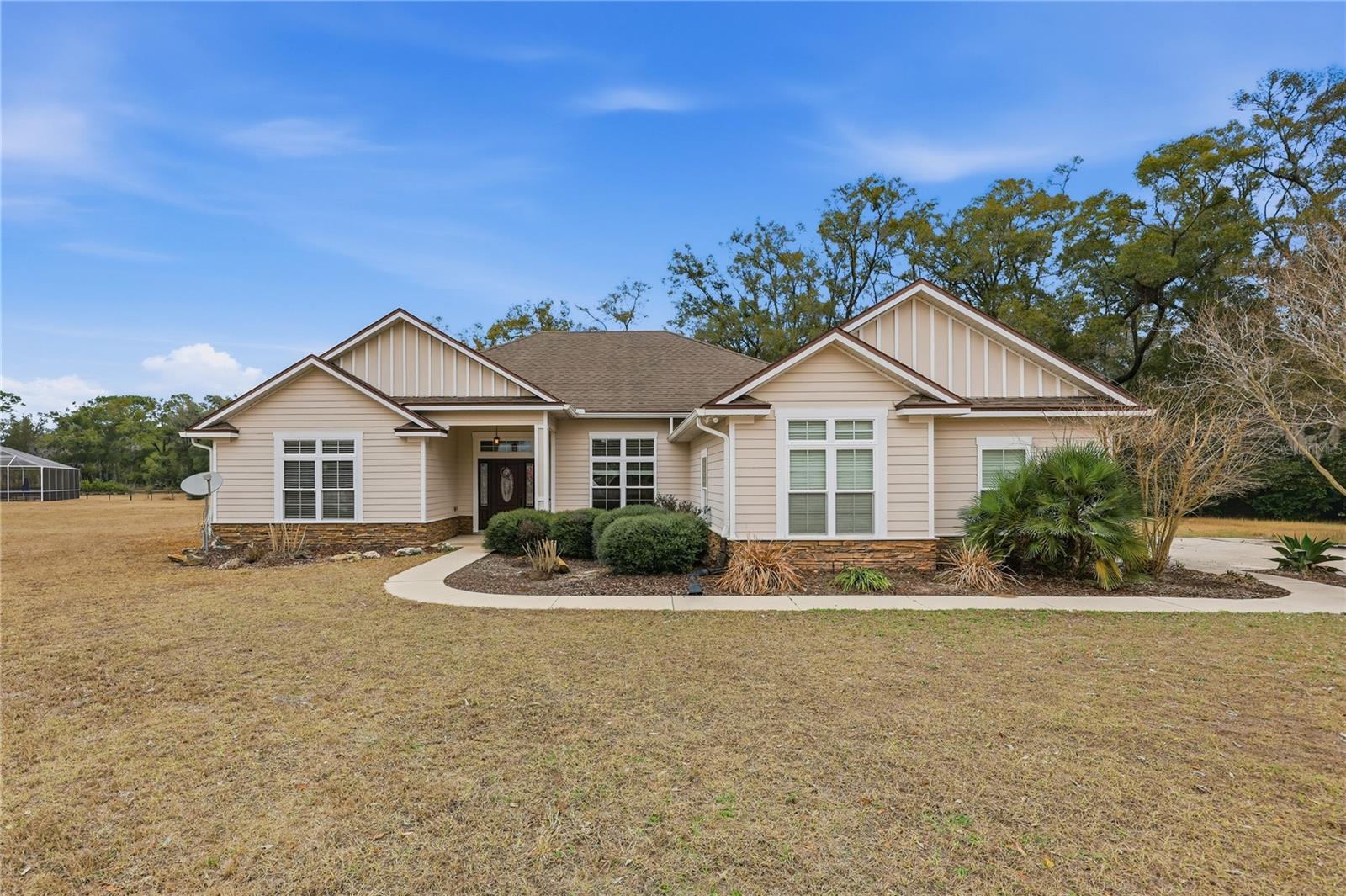 Nestled in the picturesque town of High Springs, this ranch style home boasts a prime location in the desireable gated community of Cinnamon Hills Estates. This 5 bedroom & 3 bathroom home sits on 1.22 acres, at the end of a cul-de-sac & woods behind the home. Enter into the home to a split floor plan & open living space & vaulted ceilings. The home has granite counters in the kitchen & bathrooms, stainless appliances in the kitchen, a designated laundry room with a built in utility sink. Enter the primary bathroom & enjoy double sinks, a vanity space, walk in closet & stand alone shower & large garden tub. Enjoy the back yard space from the enclosed screened porch. Attached 2 car garge will meet all your storage needs!