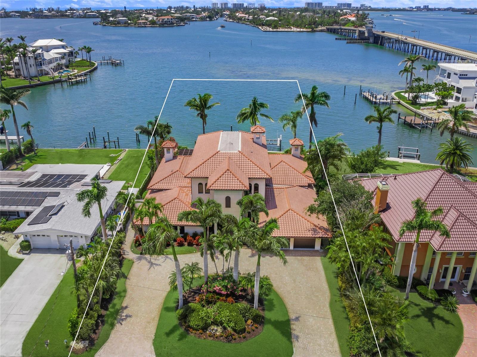 One or more photo(s) has been virtually staged. 3576 San Remo Terrace – A Waterfront Masterpiece in Sarasota
Discover the pinnacle of coastal luxury at this exquisite estate, nestled in the highly sought after San Remo Estates. Offering the best views over Roberts Bay, this 6,091-square-foot residence seamlessly blends timeless elegance, modern sophistication, and unparalleled waterfront access. With an unrivaled location & architectural grandeur it is positioned just over the North Bridge to Siesta Key, this estate delivers spectacular bay views without the flood risks or accessibility challenges often associated with barrier island living. Set on the preferred side of San Remo Terrace, the home enjoys mesmerizing sunset panoramas, deep-water access to the Gulf, and a private, tree-lined setting.

A grand custom entryway welcomes you into a world of refined luxury, where turquoise water vistas and the gentle movement of passing boats create an immediate sense of tranquility. The circular paver driveway, lush tropical landscaping, and striking architectural design set the tone for an extraordinary living experience. Designed for entertaining and everyday indulgence. The expansive open floor plan is tailored for both grand gatherings and intimate moments. A grand salon, spacious family room, and a fireplace-accented dining space establish an inviting atmosphere for hosting.
The chef’s kitchen is a culinary masterpiece, featuring dual islands with exotic stone countertops, a six-burner gas stove with griddle, double ovens, warming drawer, and an oversized refrigerator/freezer—crafted for culinary excellence.
A wet bar and 625-bottle climate-controlled wine room provide the ultimate setting for connoisseurs and casual entertainers alike.
With 4 bedrooms, 4.5 baths, an oversized office, and a versatile upstairs entertaining space, this home offers unmatched comfort and functionality. The primary suite on the main floor serves as a serene haven, complete with a luxurious en suite bath, while a private guest suite on the second floor ensures exclusivity for visitors.

Step outside into a world of unparalleled alfresco luxury.
A resort-style infinity-edge pool takes center stage, surrounded by an expansive paver deck with multiple seating and dining areas—perfect for sun-drenched afternoons or moonlit gatherings.
Lush landscaping wraps this serene retreat, creating an oasis for relaxation or playful indulgence.
For boating enthusiasts, this estate presents unmatched access to Sarasota’s famed waterways.

Brand-new dock & 10,000-lb boat lift
Kayak & paddleboard access
Fortified seawall
The Best of Sarasota Living! This home offers effortless proximity to downtown Sarasota, Siesta Key’s award-winning beaches, fine dining, top-tier schools, and world-class healthcare facilities.

Don’t miss the rare opportunity to make this timeless, Tuscan, luxurious waterfront estate your own!