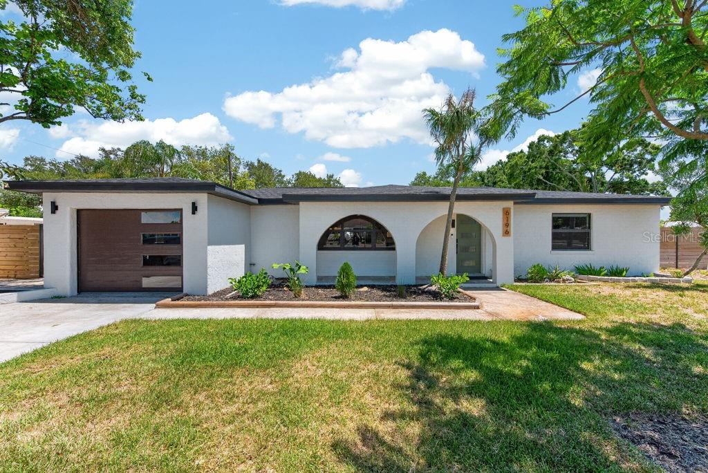 Before you even step through the front door, this beautifully renovated Kenneth City home makes a memorable first impression with exceptional curb appeal, designer finishes, major system upgrades, and a private resort-style backyard—all in an unbeatable location. Situated on a desirable corner lot in an X-500 flood zone, this 3-bedroom, 2-bath residence requires no flood insurance and has no HOA, offering both peace of mind and the freedom to enjoy your property your way. A welcoming covered front porch, professionally maintained landscaping, and front-yard irrigation set the stage for what's inside. The thoughtfully designed open-concept floor plan seamlessly connects the living, dining, and kitchen spaces, creating an ideal setting for both everyday living and entertaining. A sleek modern fireplace anchors the living room, while the stunning kitchen features custom cabinetry, stone countertops, stainless steel appliances, and an oversized center island with bar seating. Adjacent to the kitchen, the dining area is enhanced by a stylish dry bar and designer lighting, making it equally suited for casual meals or hosting guests. A split-bedroom layout provides privacy and functionality. The spacious primary suite is tucked away on one side of the home and offers a walk-in closet along with a beautifully updated en-suite bath. Two additional bedrooms and a fully renovated guest bathroom are situated on the opposite side of the home. Step outside to your own private backyard retreat. The covered patio overlooks a sparkling pool surrounded by low-maintenance turf, creating a true resort-style atmosphere perfect for entertaining, relaxing, or enjoying the Florida sunshine. The fully fenced yard provides ample room for pets and play, while the oversized storage shed offers exceptional space for tools, outdoor equipment, or hobbies. Beyond its beautiful finishes, this home has been extensively updated for long-term peace of mind, including a new roof, new HVAC system and ductwork, new water heater, complete plumbing replacement, and a full electrical rewire. Conveniently located less than 15 minutes from Downtown St. Petersburg and just a short drive to award-winning Gulf beaches, shopping, dining, and entertainment, this move-in-ready home delivers the perfect combination of style, comfort, and location. ***FREE 1/0 Rate Buydown when using the seller's preferred lender!***