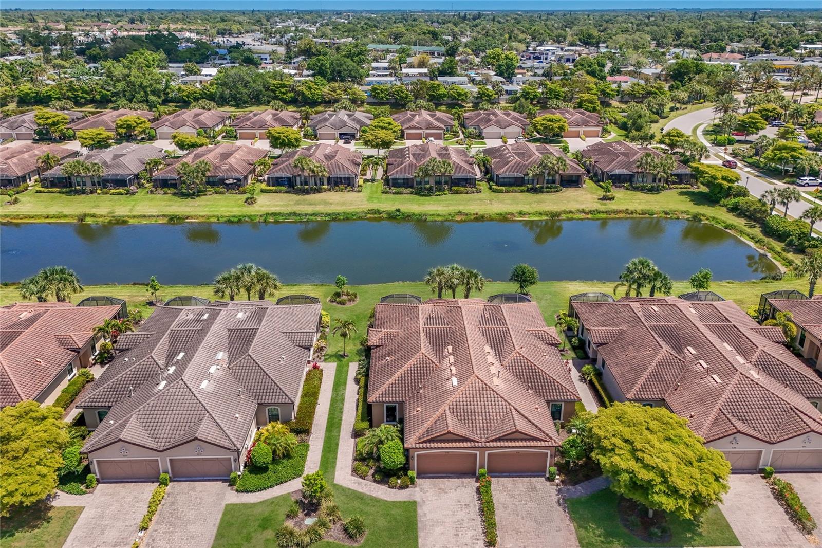Virtually Staged. Beautifully maintained LAKEFRONT HOME with a fabulous lake view! With 1,639 square feet of living area, this thoughtfully designed residence features a private walkway to the front door. The front door has a sliding screen so you can enjoy the fresh Florida breeze. You enter this home and enjoy the very open great room accented by a high coffered ceiling. The design is the very popular Great Room open to the Kitchen floor plan. Separate Dining Room

also features a high coffered ceiling accent.

The kitchen is well-appointed with granite countertops, white cabinetry, stainless appliances, loads of kitchen cabinets and a pantry. The breakfast bar is ideal for casual dining or entertaining. There are two spacious bedrooms PLUS a den/office. Additional highlights include window blinds throughout, full patio slider vertical blinds, the den features a built-in home theater system with TV and surround sound and a Murphy bed for when extra guests visit! Enjoy the extended lanai
accented by brick paver flooring and a beautiful lake vista! Lanai patio furniture, some great room furniture and bedroom furniture is included in the sale price.  NEW hurricane rated windows plus the lanai has electric roll down hurricane protection. 2 car garage with storage shelves and pull down ladder with attic flooring for extra storage. This beautiful home is in close walking distance to the Clubhouse and resort pool.
Esplanade by Siesta Key is a gated, amenity-rich community with an on-site manager, clubhouse with scheduled activities, resort-style pool and spa, fitness center, tennis and pickleball courts, dog park, and outdoor gathering areas overlooking the lake. IMPORTANT: The HOA Fee includes exterior landscaping care AND exterior building Maintenance, and the use of all the Club Facilities!

Conveniently located near shopping, dining, and everyday conveniences, and just a short drive to Siesta Key Beach. Sarasota’s vibrant arts and cultural scene, along with nearby UTC Mall, provide endless options for entertainment and recreation.