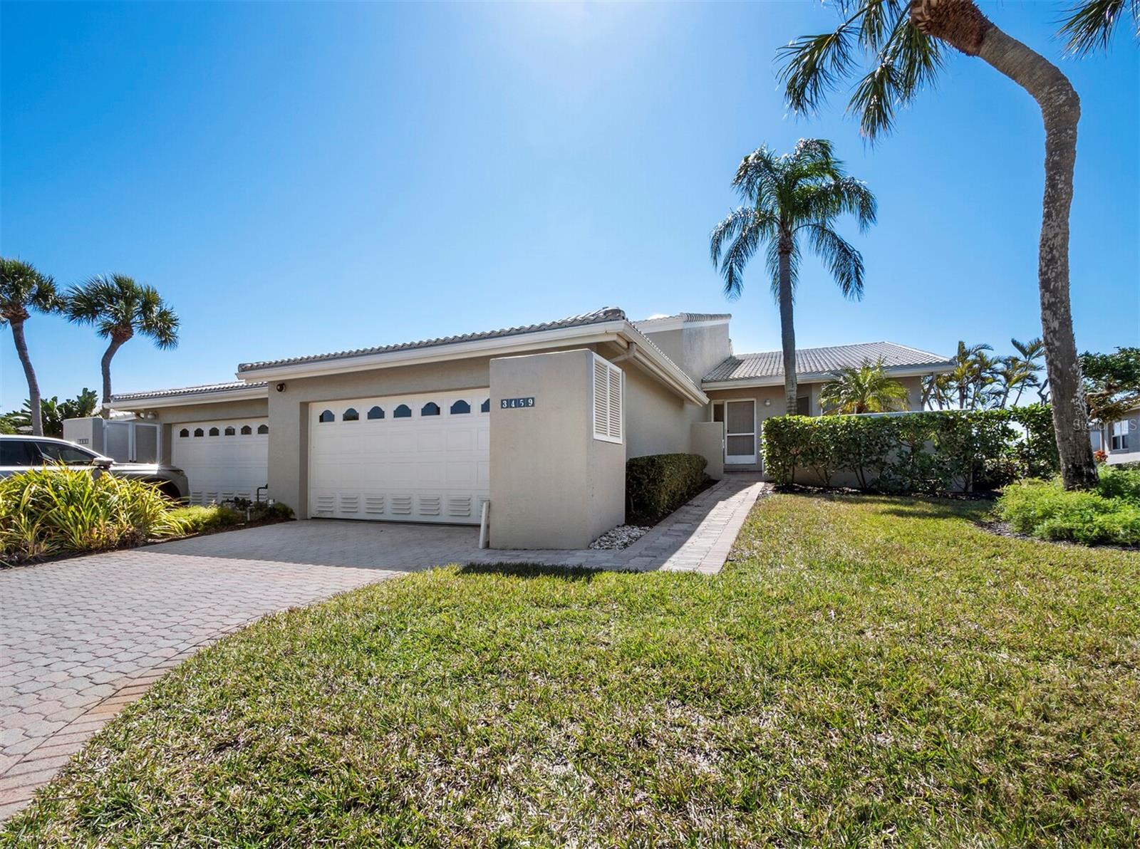 Positioned along the par-5 fairway with tranquil lake views beyond, this well-priced attached villa offers an inviting opportunity in one of Longboat Key’s most desirable neighborhoods. Set within Corey’s Landing, tennis courts sit just across the street and the beach is moments away, creating a lifestyle that balances recreation, relaxation and everyday ease. A quaint paver walkway leads to the front entrance, where tile floors, soaring cathedral ceilings and an abundance of windows create an interior that feels open, light and comfortable from the start. The floor plan flows naturally, connecting living and dining spaces in a way that works equally well for quiet days at home or gathering with friends. The kitchen is functional and ready for a future refresh, currently finished with all-white cabinetry and appliances, plus a breakfast bar that adjoins the dining area and living room. From here, a wall of glass and sliders opens to an expansive two-level screened lanai with both covered and open areas. It is a wonderful extension of the living space, offering room to dine, lounge or simply enjoy views of the fairway and water while watching play unfold on the course. The primary suite is generously sized, highlighted by a cathedral ceiling, direct lanai access and a spacious bath with freestanding tub, walk-in shower and dual vanities. A comfortable guest bedroom includes its own en suite bath, while a third bedroom currently functions as an office, offering flexibility for guests or hobbies. Residents of Corey’s Landing enjoy a relaxed, amenity-rich setting with a pool and spa, tennis courts, deeded beach access and a private beach club, all tucked behind the gates of Bay Isles. Memberships to the Longboat Key Golf & Tennis Country Club and access to deepwater slips are available. Large dogs are permitted with some restrictions, completing a setting that blends value, location and the ease of island living on Longboat Key.