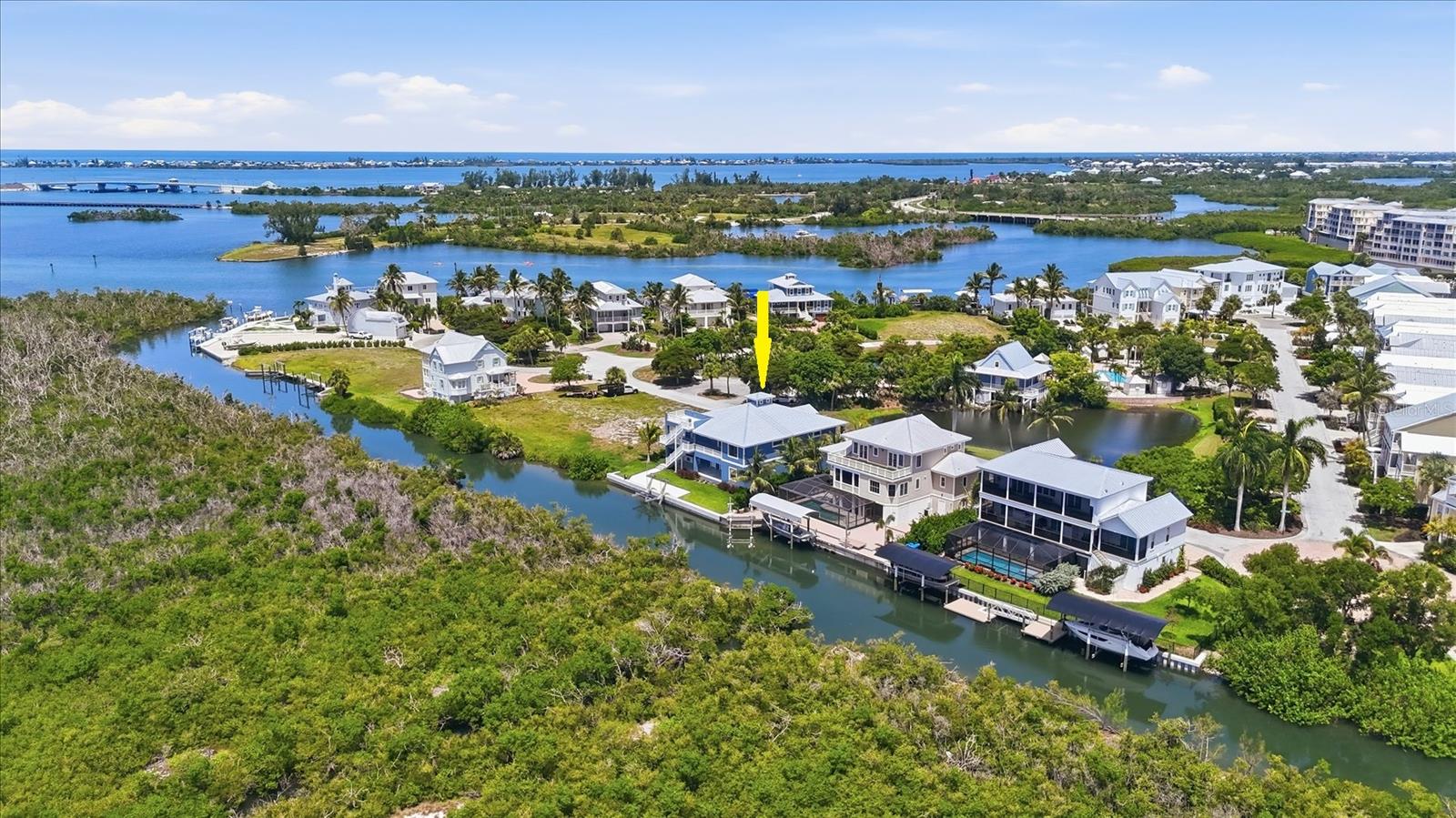 One or more photo(s) has been virtually staged. 3 Bedroom, 2 ½ bath elevated coastal living in this NEWLY BUILT WATERFRONT CUSTOM HOME featuring private panoramic views and a 13,000-lb BOAT LIFT. Constructed to the highest standards, this exceptional residence offers block construction, a metal roof, impact-rated windows and doors, composite stairs, vinyl railings, and a paver driveway. Inside, refined craftsmanship is showcased throughout with porcelain tile flooring, custom cabinetry and built-ins, crown molding, and elegant box molding accents. The luxurious primary suite features dual walk-in custom closets and a spa-inspired en suite bath with separate vanities, a soaking tub, and an oversized multi-head walk-in shower with a tankless water heater. Designed for both everyday comfort and entertaining, the gourmet kitchen includes a large quartzite island with a porcelain farmhouse sink, pot filler, display cabinetry, range, wall microwave, and an additional built-in oven. Guest bedrooms each offer private balconies and share a beautifully appointed bath with dual sinks. Outdoor living is just as impressive, with two rear lanais finished in porcelain tile, plus a lower-level outdoor kitchen complete with a grill, sink, and refrigerator. An upper observation deck provides sweeping water views and unforgettable nightly sunsets. The oversized garage accommodates up to four vehicles and includes ample storage for beach gear and boating equipment. A rear concrete pad is in place with the new 13,000-lb lift! The canal leads to open water with no bridges out to the ICW and Gulf waters! Angler’s Club amenities include a resort style pool, community dock, and gated entrance and is located adjacent to Gasparilla Marina with a restaurant, fuel, service and a ships store!
