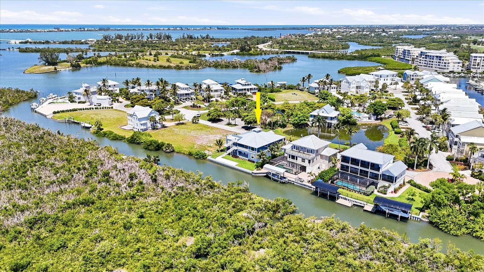 One or more photo(s) has been virtually staged. 3 Bedroom, 2 ½ bath elevated coastal living in this newly built waterfront custom home featuring private panoramic views and a 13,000-lb boat lift. Constructed to the highest standards, this exceptional residence offers block construction, a metal roof, impact-rated windows and doors, composite stairs, vinyl railings, and a paver driveway. Inside, refined craftsmanship is showcased throughout with porcelain tile flooring, custom cabinetry and built-ins, crown molding, and elegant box molding accents. The luxurious primary suite features dual walk-in custom closets and a spa-inspired en suite bath with separate vanities, a soaking tub, and an oversized multi-head walk-in shower with a tankless water heater. Designed for both everyday comfort and entertaining, the gourmet kitchen includes a large quartzite island with a porcelain farmhouse sink, pot filler, display cabinetry, range, wall microwave, and an additional built-in oven. Guest bedrooms each offer private balconies and share a beautifully appointed bath with dual sinks. Outdoor living is just as impressive, with two rear lanais finished in porcelain tile, plus a lower-level outdoor kitchen complete with a grill, sink, and refrigerator. An upper observation deck provides sweeping water views and unforgettable nightly sunsets. The oversized garage accommodates up to four vehicles and includes ample storage for beach gear and boating equipment. A rear concrete pad is in place with the new 13,000-lb lift currently being installed! The canal leads to open water with no bridges out to the ICW and Gulf waters! Angler’s Club amenities include a resort style pool, community dock, and gated entrance and is located adjacent to Gasparilla Marina with a restaurant, fuel, service and a ships store!