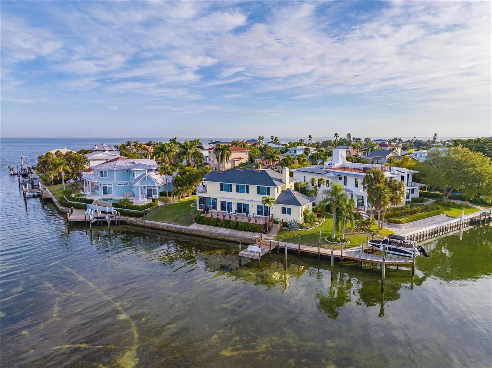 Here is your opportunity to connect with the natural world in a unique fashion on Anna Maria Island.  This unparalleled location at the northern-most point of Key Royale Drive offers expansive 230 degree views of Bimini Bay and beyond.  The lovely coastal home is a blend of beauty, luxury and elegance, all arrayed so as to enhance the relationship between the home’s interior and its natural surroundings.  As you walk through the front entrance the dazzling waters greet you immediately, and you will enjoy the illusion of standing on the bow of your own yacht.  Dolphins and manatees entering or leaving Bimini Bay cruise casually past the large deck and under each of your two docks.  Watch pelicans, ospreys and other shore birds soar and dive for fish mere feet from your seawall.   The sun sets directly opposite the deck, a nightly show that rarely disappoints.  The dock system includes two lifts, for a boat and a kayak, plus room for a large sailboat along the side.  Truly a boater’s paradise, the lifts are protected from the wind and offer direct access to Tampa Bay and the Gulf of Mexico.    

 Only two families have owned this home, and the meticulous care is evident in the details.  Hickory wood floors on the main floor, granite countertops in the open kitchen, and high impact sliding doors and windows throughout the house create a spectacular, quiet and safe interior.  There are four bedrooms, 3 ½ baths and a large two car garage.  The huge master bedroom on the second floor has two full length picture windows overlooking the water and a private outside balcony for early morning coffee, afternoon yoga or late night stargazing.    Located in the North Point Harbor neighborhood of Key Royale on a cul-de-sac, this property includes free access to North Point’s community swimming pool and tennis/pickleball court.  The first tee at Key Royale Club, the only golf course on the island, is a seven minute walk from the front door.  The Key Royale Club also offers a fine restaurant and many social activities.  If you have been searching for an exceptional water-front property on Anna Maria Island, call today for your private showing.