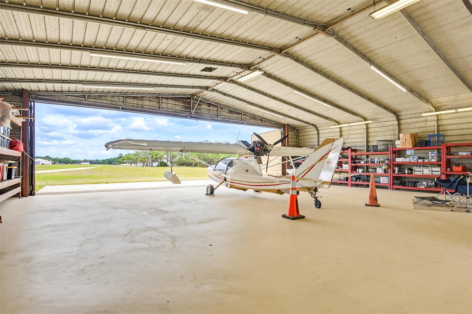 Fly-in, fly-out Central Florida airpark Home with private hangar, direct runway access to 34FD, approximately 10 total acres, and no HOA. Designed for pilots, backcountry flying enthusiasts, fly-in camping, outdoor living, and buyers seeking privacy, acreage, and lifestyle near Florida’s coast. Zoned A1

This custom 3-bedroom, 3-bath home features high ceilings, natural light, renovated kitchen, built-in wet bar, coquina stone fireplace, spiral staircase, metal roof, solar water heater, screened lanai, multiple screened patios, summer kitchen, and custom outdoor entertaining space. The upstairs multi-purpose area is ideal for an office, guest space, hobby room, or private retreat.

Aviation features include a 50x50 airplane hangar totaling approximately 2,500 sq. ft., 40’ x 11’ hangar door opening, 14’ RV door, upgraded LED lighting, insulated roof coating, and direct access to an approximately 3,400 ft. runway. Perfect for aircraft storage, private aviation, fly-in gatherings, backcountry flying, and aviation lifestyle living.

The estate offers open land, wooded privacy, stocked pond with fountain, beach area, seawall, mature oaks, horse barn with 2 stalls and corral, RV/boat parking, three RV hookups with 50/30 amp service, fish cleaning station, irrigation, and private trails. Located approximately 270 feet from the Maytown Spur, offering easy bike access without loading gear.

Two additional buildable lots create potential for guest accommodations, multi-generational living, additional structures, or income-producing opportunities. Near New Smyrna Beach, boating, trails, shopping, and major travel routes.

Buyer and buyer’s agent to verify all measurements, acreage, zoning, land use, buildability, runway access/use, trail distance, rental potential, and income-producing opportunities.