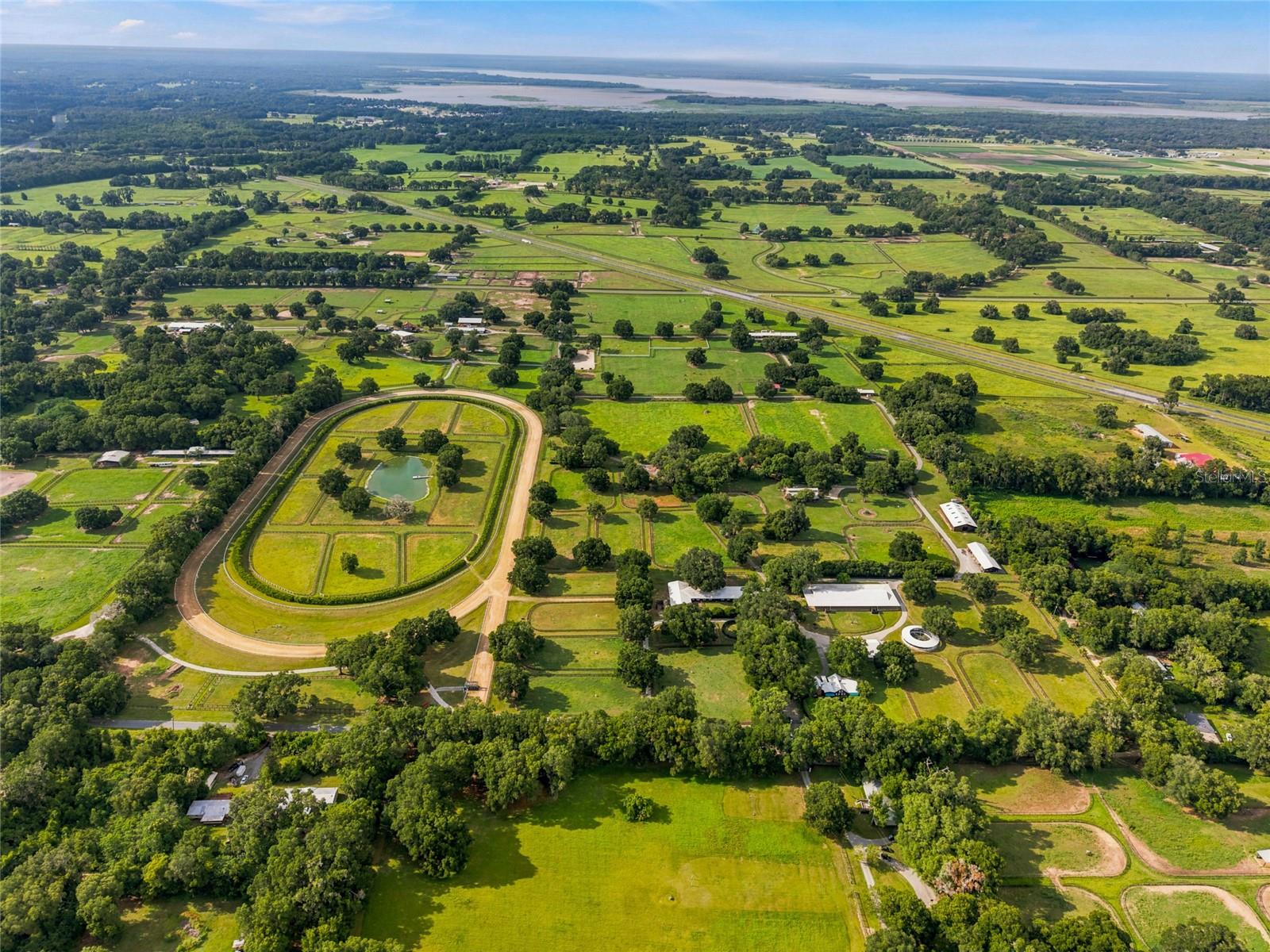 Towering granddaddy oaks, lush paddocks and the quintessential equestrian lifestyle await.
A genuine showcase of NW Marion County’s horse country, this 36± acre farm is nestled beneath a canopy of majestic granddaddy oaks, where plentiful green pastures, well-maintained grounds and a peaceful setting create that equestrian haven. Whether you're looking for a successful thoroughbred operation or wanting a premier sport horse facility, this property offers an incredible opportunity in a continuously growing location. Only 30 minutes to the World Equestrian Center, HITS, downtown Ocala, and Gainesville, and only 5 minutes to Majestic Oaks and 10 minutes to the future WEC Jockey Club, makes this farm perfectly positioned to enjoy the peace and beauty of Ocala’s horse country while remaining just minutes from premier equestrian venues, shopping, dining and everyday conveniences.
The facilities include two barns with 48 block stalls, office, tack and feed rooms, restroom, wash racks, a Theraplate stall, a 60-foot European Eurociser with crushed rubber footing and water system, a hot walker, round pen and a large workshop complete with a break room, storage area, washer and dryer and plenty of equipment storage. 30 paddocks and pastures, new four-board fencing, Wi-Fi throughout the farm, camera security, an RV hookup, and a full-house generator further enhance the property’s practicality.
There is a 5/8-mile irrigated training track with a 1/2-mile inner turf track, viewing stand, with 11 of the lush interior fields surrounding a fully stocked pond that creates both a tranquil centerpiece and a relaxing place to unwind.
The inviting residence blends rustic mountain charm and refined warm living. The wood work and cathedral ceilings are beautiful and cozy. The kitchen features abundant cabinetry, a gas cooktop, double built-in ovens and a breakfast bar. Step outside to your own private oasis with a sparkling saltwater pool and spa, expansive pool deck, outdoor entertaining area with kitchen and shaded gathering spaces perfect for relaxing after a day at the barn.
Combining the timeless beauty of mature granddaddy oaks with well-planned equestrian amenities, this farm is ready to support a variety of equestrian pursuits, offering endless possibilities for training, boarding, investment, or creating the equestrian lifestyle you've always envisioned.