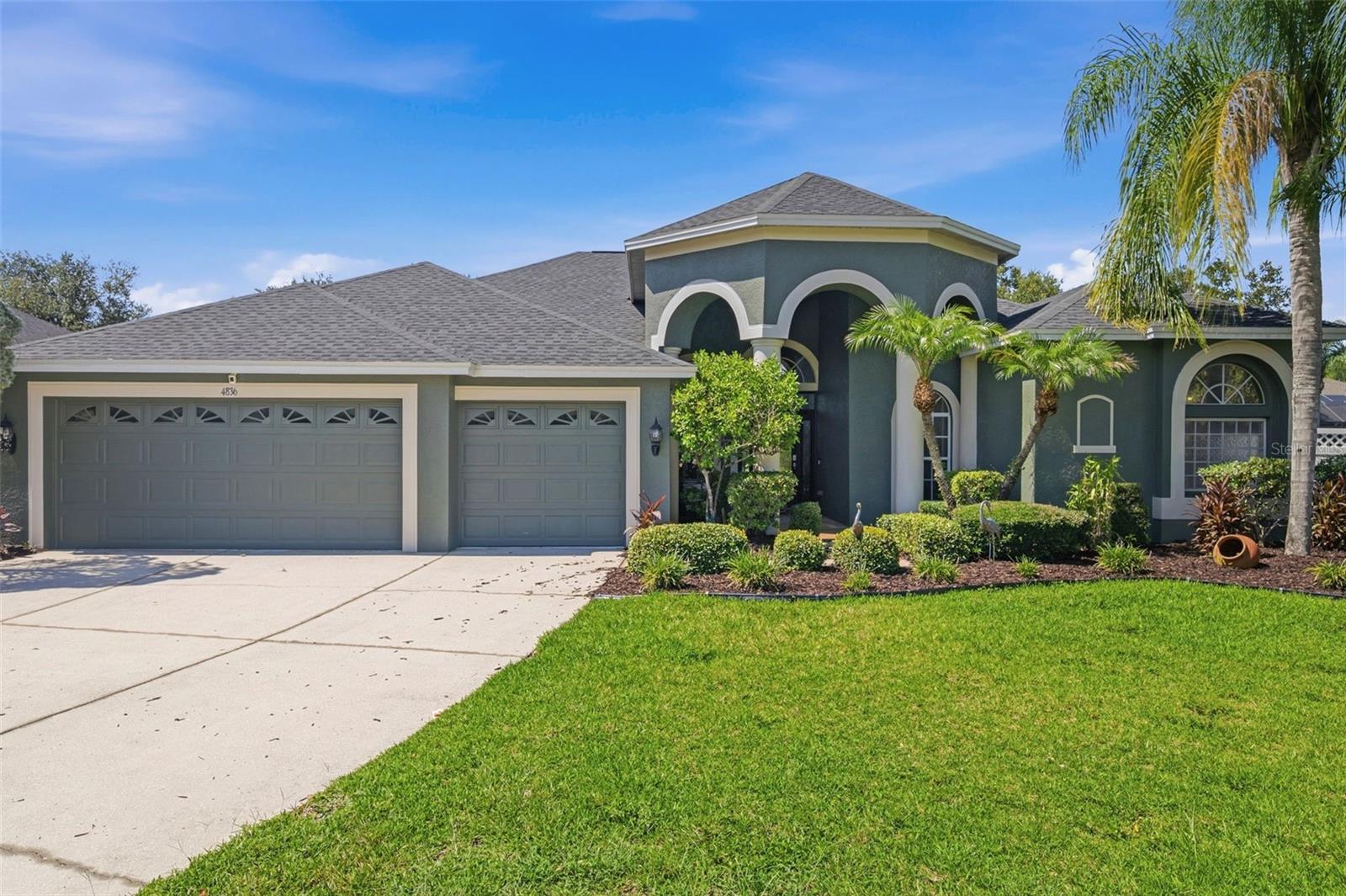 QUAINT GATED COMMUNITY. WATERVIEW. OVERSIZED LOT. Discover the space and details that set this home apart. Situated on an oversized 0.41-acre homesite, this move-in ready home offers over 3,200 square feet of living space, a fenced backyard, tranquil water views, and a spacious 3-car garage. Boasting 4 bedrooms, 3 full bathrooms, an office (optional 5th bedroom) with double entry doors and a pocket door connecting directly to the primary suite, flex space with a floor-to-ceiling built-in bookcase (optional library, playroom or den), BONUS LIVING AREA (20X20) with potential for an in-law suite or apartment, formal dining area, eat-in kitchen, family room, and covered open lanai. The third bathroom offers direct backyard access, making it ideal for a future pool bath. From the moment you arrive, the show-stopping front entry with an oversized paver porch, stately columns, keypad keyless entry, arched transom windows, glass front door with sidelights. Inside, find arched doorways, crown molding, chair rail, baseboards, arched transom windows, and abundant natural light. Designed for indoor-outdoor living, glass sliders from the primary suite, formal dining room, family room, and bonus room seamlessly connect to the covered lanai and backyard. The eat-in kitchen showcases a 90-degree glass window overlooking the backyard, abundant wood cabinetry with glass display cabinets, top-of-the-line Café Series appliances including a panel-ready refrigerator, double oven range, built-in Air Fry microwave, dishwasher, walk-in pantry, commercial-style pull-down faucet, generous counter space, oversized double sink, prep sink with garbage disposal, and breakfast bar. The primary suite offers a spacious sitting area with a built-in window bench overlooking the backyard, glass sliders leading to the lanai, two walk-in closets with built-in organizers, and an adjoining office connected by a pocket door, creating the perfect space for a home office, nursery, fitness room, or optional fifth bedroom. The updated primary bathroom features dual vanities, a makeup area, jetted spa tub accented with herringbone tile, walk-in shower, and two arched transom windows. The laundry room includes cabinetry, utility sink, washer, and dryer. Professionally installed sun-reflective film on windows and sliders enhances comfort and energy efficiency. Fresh interior paint (2026), new sod and mulch (2026), and recent pressure washing (2026). Major improvements completed between 2024 and 2026 include a new roof (2024), two Trane HVAC systems (2024), two mini-split systems (2024), Stiebel Eltron tankless water heater (2024), commercial-grade luxury vinyl plank flooring (2024), Café Series kitchen appliances (2025), kitchen faucet (2026), professionally refinished guest bathroom tub (2026), and primary bathroom updates (2026). The oversized fenced backyard offers room for pets, play, gardening, or a future pool while enjoying peaceful water views, a covered lanai, and exceptional privacy. Lake Talia offers low HOA fees, no CDD fees, scenic lakes, mature landscaping, abundant wildlife, a playground, basketball court, and convenient access to shopping, dining, I-75, Veterans Expressway, and top-rated schools, including Land O' Lakes High School one of Pasco County's premier magnet high schools and has been an authorized International Baccalaureate (IB) World School. Buy a Little Piece of Florida Now!