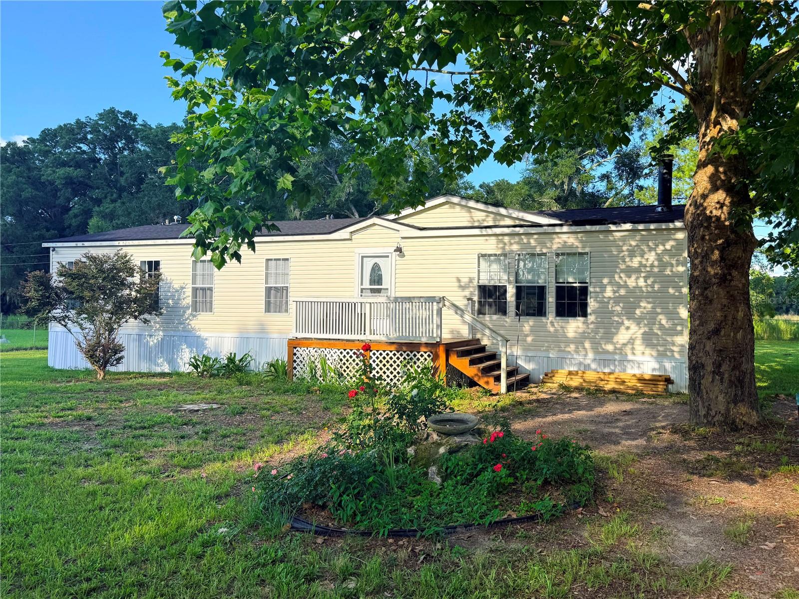 [3/2 MH on 1.11 Acres with NO HOA, move-in ready]. NEW ROOF and NEW flooring in the kitchen, living room, bathroom, and utility room in 2023! Wood burning fireplace in sunken living room on 1.11 acres tucked in a private setting with no through traffic. Just a short drive to High Springs/Alachua and Lake City.COLUMBIA COUNTY TAXES make it worth the short drive over and out of Alachua county! Move in ready! The floor plan features open living area with fireplace and built-in cabinets, kitchen has over sized island/bar, stainless steel appliances and master bathroom with double sinks, garden tub and separate shower. Water Purification system in storage shed. The 1.11 acre lot has plenty of room and sunshine for pets, gardening, outdoor entertaining and dark skies at night to see the stars and planets. Land is high and dry, flat, fully fenced. Ready for new owner to love living in the convenient country setting. New drain field 2021. Seller has recently completed many updates and fixes to this home. Mature pine and oak trees and vegetation has also been newly planted. New storage shed contains well and water purification systems - will convey. ALL dimensions and square footage values must be verified. Very well cared for and clean mobile home. Past home inspection was very clean. Interior pics uploading FRI 06/26/26. {smls}
