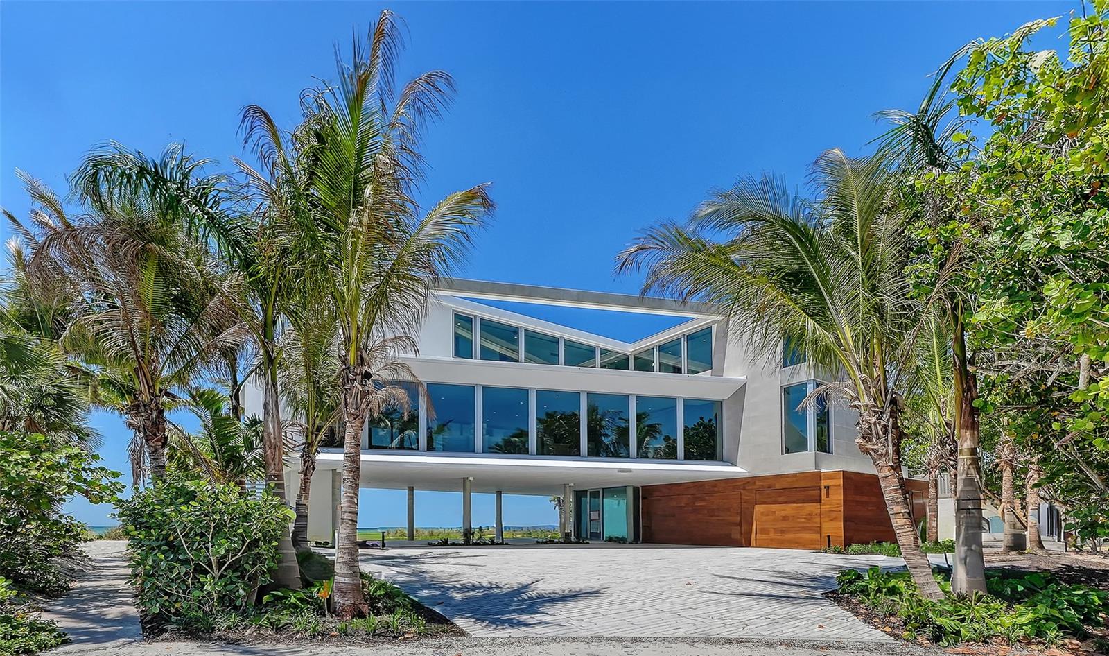 Under Construction. You're in for something special with this new beachfront construction set to be completed by May, 2026. Located on over a quarter acre on Longboat Key, this contemporary luxury home is directly on the beach with stunning Gulf views. Designed with a modern coastal aesthetic, it’s built for both style and comfort. Inside no detail is overlooked. From sleek Walker Zanger porcelain tile to custom cabinetry and polished nickel fixtures, the finishes are top-tier. The gourmet kitchen features an expansive layout with a large waterfall-edge island, double Wolf ovens, Sub-Zero refrigeration, a full-size wine cooler, and a Wolf induction cooktop—everything you need for serious cooking or entertaining. Primary suite is a true showstopper with floor-to-ceiling glass sliders that open wide to a sweeping terrace. Gulf breezes flow through the space, and the shimmering azure water is always in view. Inside, the suite offers a spacious walk-in closet and a spa-like bath featuring tiled walls, a walk-in shower with multiple heads, a soaking tub, dual floating vanities, and a private water closet. Upstairs, an executive office and three generous bedroom suites—each with its own walk-in closet—gives plenty of space for family or guests. A fourth bedroom shares a cozy den, perfect for lounging or movie nights. The grand-level outdoor space takes full advantage of its beachfront setting with a 36-foot lap pool, sun shelf, heated spa, and a fully equipped summer kitchen with a grilling station—ideal for effortless entertaining, all just steps from the sand.