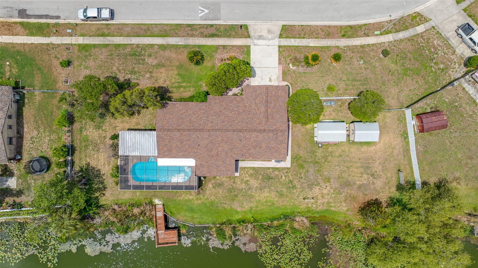 This Nature Lovers paradise is a rare opportunity to own a pool home on Lake Sangri La.  This home features 3 Bedrooms 2 Bathroom a large outside pool/patio area & a 2 car garage.  Other features include a large kitchen/dining room combination, a roomy laundry room with extra cupboard space for storage of dry goods.   Situated on a massive 193'x190' Lot backing up to Lake Shangri La, Mother Nature shows off every morning & night!  The visitors you will encounter range from Ducks, Blue Heron, Bass, Turtles, Butterflies.  A truly magnificent piece of nature.  Whether you're swimming in the pool or sipping coffee from the kitchen table you'll have a beautiful view of the lake!  Included in the sale are (2) 10X12 Sheds (one with power the other wired for power) a great place to keep your fishing gear and kayak!  This home has been very well maintained over the years by an owner who cares!  A new roof in December of 2023.  Centrally located - 1hr to Disney, 1 hr to Clearwater Beach, 20 Minutes to Tampa Airport (depending on traffic) 30 Minutes to Downtown Lakeland.  Homes like this don't come around every day.