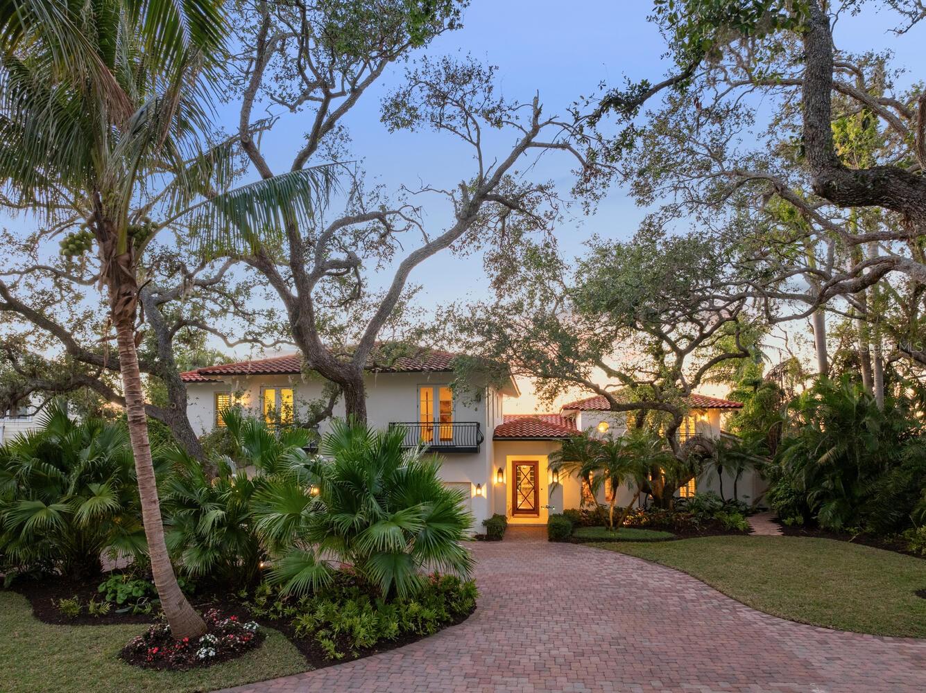 A testament to timeless elegance and the tropical charm of coastal living, securely situated at or above base flood elevation. This exceptional Bayfront estate rests on nearly one acre, boasting 180 feet of water frontage and effective year built 2016. Fully renovated and expanded in 2017, it offers breathtaking, uninterrupted views of Roberts Bay and the intracoastal Waterway, where mesmerizing sunsets serve as a daily invitation to pause and savor the moment. Nestled privately off Red Rock Way, the property ensures tranquility and seclusion. A grand entrance leads you past the library into the casually sophisticated living room, featuring French doors, a custom coral gas fireplace, and French oak flooring. Adjacent to the living spaces, the dining room and expansive covered terrace create the perfect ambiance for entertaining, with coral flooring and a pecky cypress ceiling adding character and charm. The gourmet kitchen is a chef’s dream, showcasing custom cabinetry in painted wood and natural walnut, luxurious Calacatta gold marble and quartz countertops, Thermador appliances, a spacious island, and a convenient wet bar. The inviting family room, complete with a wood-burning fireplace and French doors, opens to yet another terrace, seamlessly blending indoor and outdoor living. The master suite is a serene retreat, featuring a vaulted paneled ceiling, a large private terrace, his-and-her bathrooms, an outdoor shower, and oversized walk-in closets. The second floor hosts three en-suite bedrooms, while a fifth guest suite offers complete privacy, making it ideal for visitors. The backyard is a true oasis, highlighted by a heated pool with a spa, surrounded by fresh landscaping, mature palms, and century-old oak trees. The waterfront dock caters to boating enthusiasts, water sports lovers, anglers, and those who enjoy soaking in the sunset views. Located west of the Trail, this remarkable estate is just minutes from world-class beaches, vibrant cultural venues, exquisite dining, and an array of recreational activities.