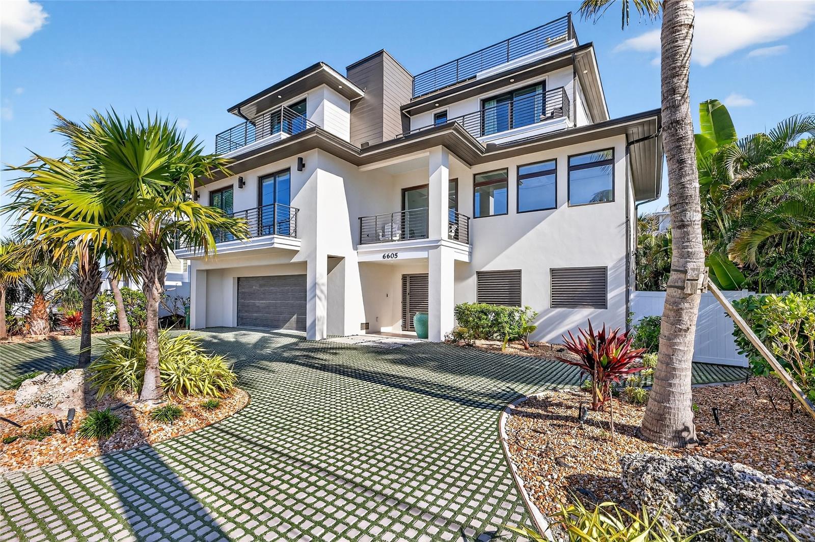 Just a few sandy steps from the shores of Holmes Beach, this newly built 4BD/4.5BA coastal haven blends elevated design with the laid back spirit of island living. A proven income generator with bookings already on the calendar, this property offers the rare opportunity to enjoy a luxury retreat that also works for you. Each of the four ensuite bedrooms offers generous space and privacy, three with private balconies, and a primary suite that stuns with sweeping Gulf views and a spa-inspired bath featuring a freestanding soaking tub. The light filled living area flows effortlessly into a sleek chef’s kitchen where a quartz waterfall island, luxury gas range, wine bar, and oversized walk-in pantry cater to everything from casual breakfasts to sunset dinners. Step outside to discover a resort style backyard designed for all day enjoyment including a heated pool and spa, cascading sheer waterfall, outdoor dining and lounge space beneath a covered cabana deck, and lush turf landscaping that’s as beautiful as it is low maintenance. For sunset seekers, the rooftop deck delivers panoramic Gulf and Bay views that make every evening feel like a getaway. Other thoughtful touches include an elevator, bonus flex space, two-car garage, circular drive, and laundry room. All of this is tucked just moments from the best of the island local boutiques and beloved restaurants, making it equally suited as a luxurious full time residence or high performing vacation rental.