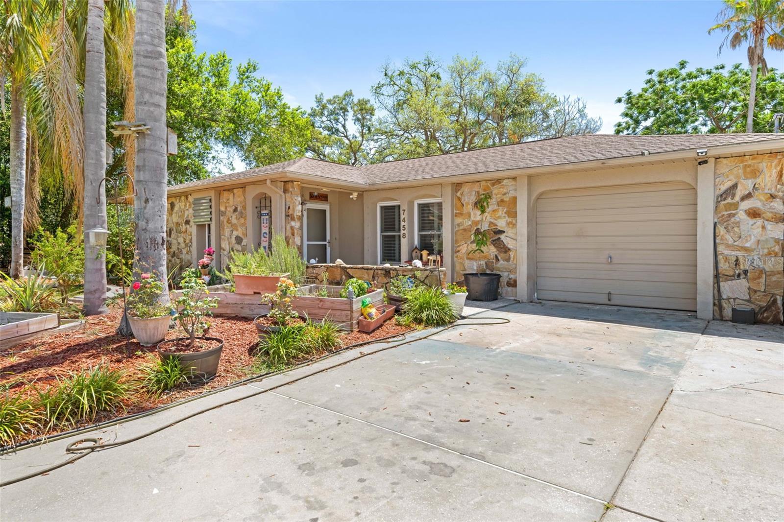 Welcome to this beautifully maintained 2-bedroom, 2-bathroom home tucked away on an oversized 0.29-acre lot in the heart of Spring Hill! Situated on a quiet street and surrounded by mature trees and lush landscaping, this property offers the perfect blend of privacy, charm, and functionality.

Step inside to discover a bright and spacious open-concept layout featuring a large living and dining area, tile flooring throughout the main living spaces, and a spacious kitchen complete with ample cabinetry, stainless steel appliances, ample counter space, and a breakfast bar perfect for entertaining. Natural light pours in through the plantation shutters and hurricane-impact windows, creating a warm and inviting atmosphere throughout the home.

The generously sized bedrooms offer comfort and flexibility, while the indoor laundry room adds convenience and the attached garage provides additional storage space. Additional upgrades include a water filter system in the kitchen for added comfort and efficiency.

Outside, enjoy your own private backyard oasis with plenty of room to relax, entertain, garden, or store your toys. The property also features multiple storage sheds, extended driveway space, and no HOA or CDD fees. Whether you’re looking for a primary residence, seasonal retreat, or investment opportunity, this home checks all the boxes.