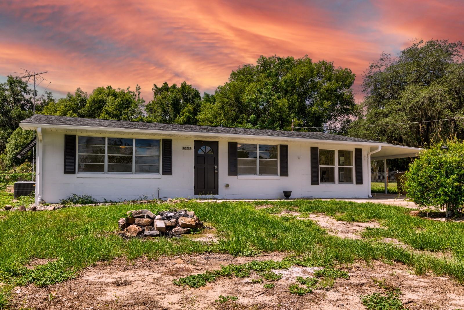 ?Move-In Ready Block Home on a Deep, Private Lot — Room to Roam
Set well back from the road down a long private drive, this fully refreshed ?3-bedroom, ?1-bath concrete block home pairs tasteful updates with the kind of land that's getting harder to find. Mature shade trees frame the front, and sharp black shutters and a striking arched-glass front door give it standout curb appeal.
Inside, the open-concept great room flows into a renovated kitchen built for gathering — crisp white shaker cabinets, classic subway tile, and stainless steel appliances including a French-door refrigerator. Durable wood-look tile runs throughout (no carpet), and custom built-in shelving adds charm and storage. Both bathrooms are updated, one with a sleek glass walk-in shower and the other with a tiled tub-and-shower combo. Washer and dryer are included.
Step outside and the lot does the talking: a wide, deep, fenced yard with mature trees, multiple storage sheds, a standing greenhouse for the gardener, and a concrete pad ready for a future workshop or garage (buyer to verify permitted uses). A covered carport offers parking plus a covered patio and extra storage. Bring the boat, the RV, the garden — there's space for all of it.
Solid block construction, thoughtful finishes, and land to make your own — all in Fruitland Park. Schedule your private showing today.