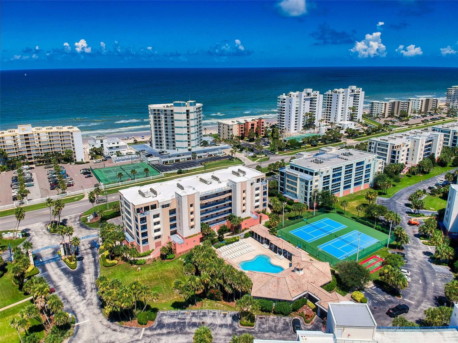 Experience coastal luxury at its finest in this beautifully upgraded, fully furnished residence in the highly sought-after Ocean Walk community. Thoughtfully enhanced from top to bottom, this exceptional condo showcases premium finishes and designer touches throughout, including top-of-the-line kitchen and laundry appliances, custom tilework, elegant wood cabinetry, soft-touch fixtures, a sleek low-profile range, built-in microwave, and an ultra-quiet dishwasher. A newer high-efficiency HVAC system, installed less than one year ago, provides year-round comfort and added value. 

Enjoy breathtaking views from every angle. The west-facing entrance overlooks the serene estuaries and Clubhouse 1 pool area, while the spacious east-facing balcony captures stunning Atlantic Ocean views with an expansive 180-degree coastal panorama. Wake each morning to spectacular sunrises from the oversized primary suite, featuring direct ocean views through large windows and sliding glass doors.

Offered fully furnished, the sale includes approximately $20,000 in high-end furnishings and décor, allowing for an effortless move-in or investment opportunity.

The luxurious primary bath offers dual wood vanities with marble countertops, extensive tile finishes, abundant lighting, a soaking tub, and a separate walk-in shower. The custom-designed primary closet provides exceptional storage with dedicated space for extensive wardrobes and footwear collections. Two guest bedrooms offer comfortable accommodations, including one with private access to the guest bath, creating a second suite ideal for family and visitors.

Additional features include secure under-building parking, a generous private storage unit, and the peace of mind of a gated community. The condominium association maintains a master flood insurance policy, providing additional value and convenience for owners.

Ocean Walk is one of New Smyrna Beach's premier gated, resort-style communities, offering deeded access to the pristine no-drive beach and an exceptional array of amenities. Residents enjoy two beautifully appointed clubhouses with full kitchens, two heated pools and spas, state-of-the-art fitness centers, tennis courts, basketball courts, bocce ball, shuffleboard, ping pong, BBQ areas, scenic walking trails, and the community's signature boardwalk nature trail. Private deeded beach access leads directly to miles of unspoiled shoreline. On-site rental management adds further convenience for owners and investors alike.

Located in the desirable Beachside South area of New Smyrna Beach, Ocean Walk offers the perfect blend of coastal beauty, resort-style amenities, and relaxed Florida living. Combining luxury, location, amenities, and value, this exceptional residence represents one of the finest opportunities available in New Smyrna Beach's beachside condo market.