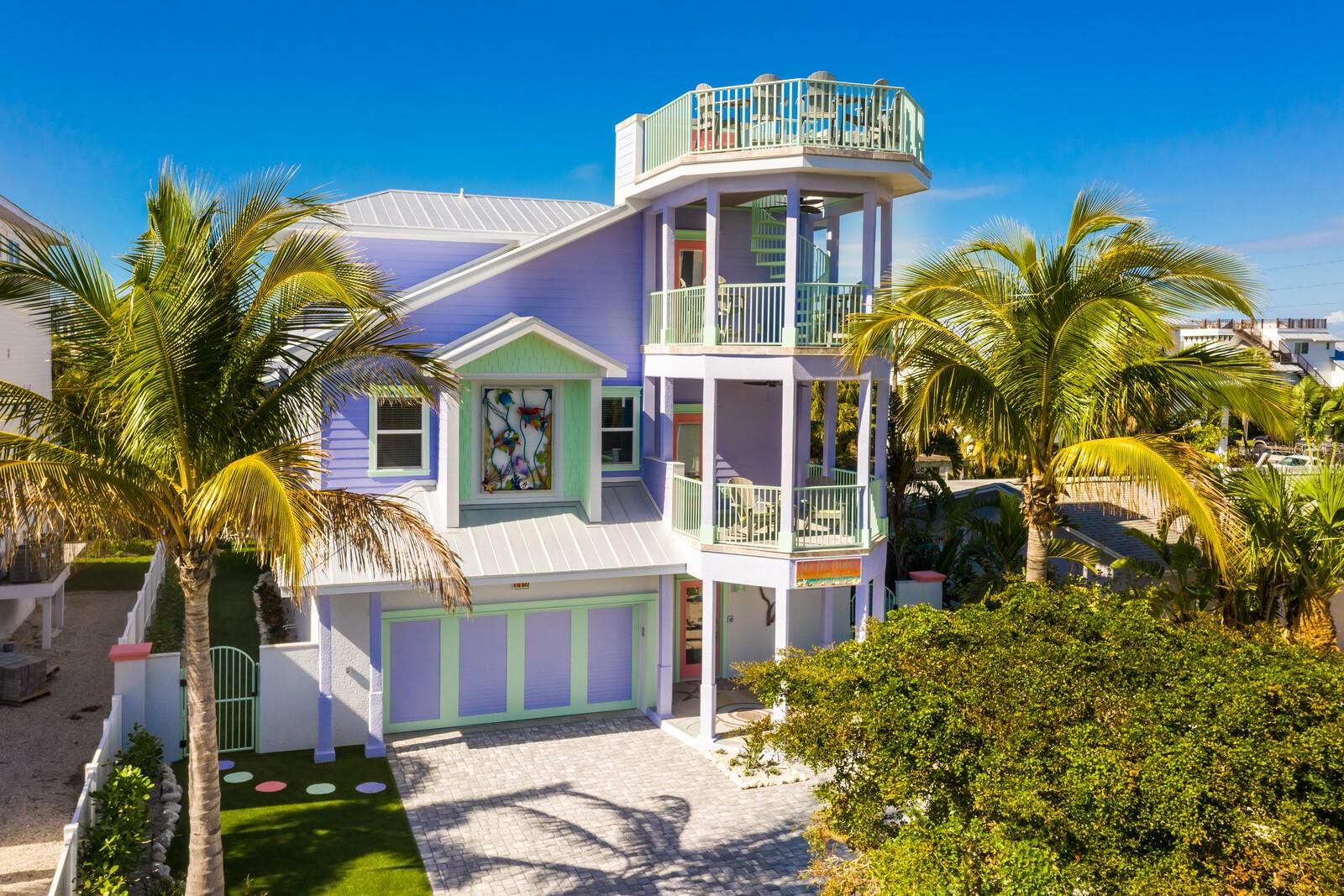 Just four houses from the beach, this stunning 4-bedroom, 4.5-bath coastal retreat by Poseidon Adventures Development Group captures the essence of Florida living. Designed for relaxation and effortless entertaining, this custom, high-performance, low-maintenance home offers exceptional comfort for both families and guests.
Thoughtfully curated with custom furnishings, high-end fixtures, and coastal artwork, the home immediately evokes a serene island ambiance. Enjoy peaceful Gulf of Mexico views from two open decks, and take in sweeping vistas of Tampa Bay and the Skyway Bridge from the upper deck.
The open-concept main living area flows beautifully, featuring a spacious kitchen with top-of-the-line stainless steel appliances—ideal for hosting gatherings. This level also includes two generous suites with en suite baths. The primary suite offers a spa-like experience with a luxurious shower, double vanity framed by artistic mirrors, and a walk-in closet. Two additional suites on the second living level provide perfect accommodations for guests.
Step outside to your private tropical oasis, complete with a sparkling pool, travertine deck, artificial turf, and lush landscaping. The adjacent recreation area features an oversized covered lounge with a summer kitchen, bar, shuffleboard table, pool table, cornhole boards, a three-hole putting green, and two large TVs—creating a resort-style environment for endless enjoyment. An elevator provides convenient access to the main living level.
Situated in the heart of Anna Maria Island, this prime location offers easy access to both the northern and southern tips of the island, as well as nearby restaurants, marinas, and boutiques. Fully furnished and turnkey, this exceptional property is the ultimate family beach retreat. Call today to schedule a private viewing!
