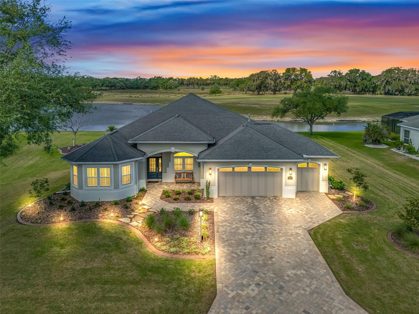 NEW ROOF (6/15/26)) LUXURY GOLF & WATER FRONT PREMIER HOME AND THE BEST VALUE ON A CHAMPIONSHIP GOLF COURSE-EXTENSIVELY RENOVATED.  Modern LUXURY is Redefined in this Modified WILLIAMSBURG located in the COVETED Premier Home Neighborhood Bridgeport at Lake Sumter Landing. Every change and upgrade was thoughtfully curated to leave nothing for the NEW OWNERS to do but unpack and start enjoying the lifestyle they've worked for. This OVERSIZED PREMIER HOMESITE has room to expand on both sides and behind. Situated on #1 RILEY GROVE CHAMPIONSHIP COURSE (Arnold Palmer Country Club) you have Panoramic views of the Tee Box, Green and Water (No golf cart path invading your privacy. The Curb Appeal upon arriving is CLEAN lines with refreshed Landscaping, New Exterior LIGHT Fixtures, Pavered Drive and Walkway, New Haas Insulated Garage Doors (w/quiet operating system, remote camera/access capability), PROVIA TRIPLE paned Front Door along with NEW WINDOWS(transferable warranty).  WOOD FLOORING elevates the home upon entry, and it only gets better. The kitchen is a dream with new cabinetry to the ceilings, BOSCH appliances (except for Gas stove which is KitchenAid), Range Hood, Island, QUARTZ counters that have been lowered to enhance  the view, Subway Tile Backsplash, Oversized sink, BRONDELL 3 Stage Water Filtration Stystem and Coffee Bar/Wine Refrigerator in the breakfast nook.
The open-concept layout flows beautifully, creating an ideal setting for hosting and everyday living. The PRIMARY SUITE serves as a true sanctuary. The spa-inspired primary bath is nothing short of exceptional with an oversized walk-in shower w multiple shower fixtures, dual vanities, cabinetry tower and illuminated mirrors. With the removal of the garden tub an additional walk-in closet was added, still having 2 CUSTOM Closets in the Primary Bedroom. The Guest Quarters have a sliding pocket door for privacy with 2 Bedrooms and Updated Bath with DUAL SINKS. The Front Guest room has a Murphy bed (no closet) while the back guest room has direct access to the 2nd Bathroom. The Oversized Lanai has 3 remote privacy screens, a beautifully painted wood, tongue and groove ceiling, and enough room to host family gatherings, club or neighborhood parties. On chilly nights relax around the Firepit and watch the Sunset. The Garage has an epoxied floor, Storage Cabinets & work area, extra refrigerator and GOLF CAR GARAGE has room for 2 tandem golf cars. This ONE-OF-A-KIND home has plantation shutters throughout, new lighting, rounded corners, 5 1/4" Baseboards, Chair railing and so much more. HVAC 2019