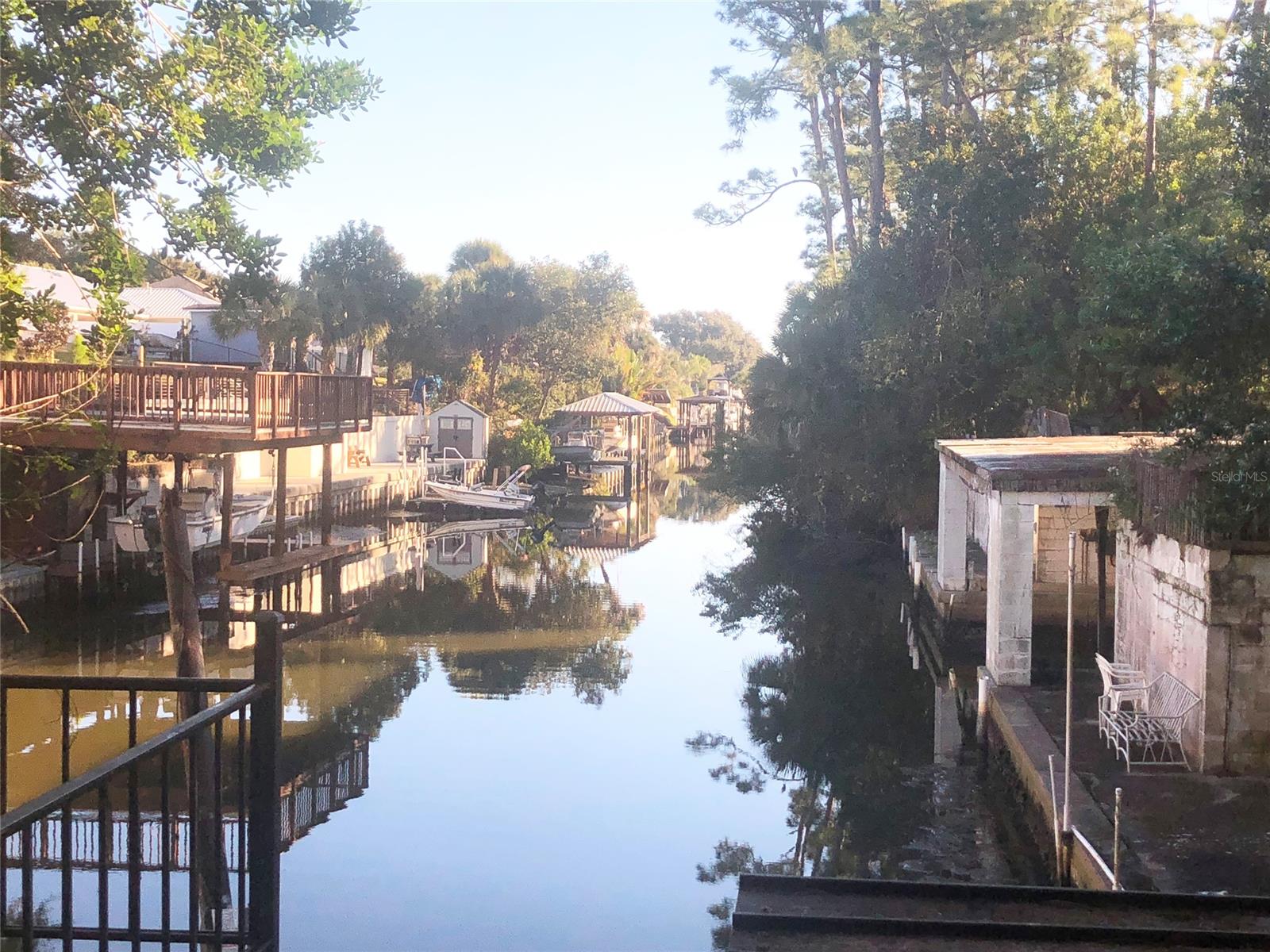 WATERFRONT HOME ON LARGE, HIGH, CORNER LOT!! BEAUTIFUL WOODED SETTING AROUND THIS LOVELY CONCRETE BLOCK HOME. BIRDS AND WILDLIFE CAN BE OBSERVED FROM THE LARGE FLORIDA ROOM. FLORIDA ROOM IS CARPETED. LARGE RETAINING WALL BUILT TO SECURE LAND AROUND HOME AND PROTECT AGAINST ANY EROSION. THE OPEN FLOOR PLAN HAS A WOOD BURNING FIREPLACE. TWO LARGE BEDROOMS AND TWO FULL BATHS. LOTS OF CABINETS AND LOTS OF STORAGE. LARGE GARAGE WITH SIDE DOOR EXIT AND GARAGE DOOR OPENER. MOP SINK IN GARAGE WITH NEWER WASHER AND DRYER. BIG BEAUTIFUL FLORIDA ROOM OVERLOOKING THE DEEP WATER CANAL THAT FLOWS TO THE INTRACOASTAL WATER. STRONG CONCRETE SEAWALL AND DOCK WITH BOATHOUSE. YOU MUST SEE THIS HOME!!