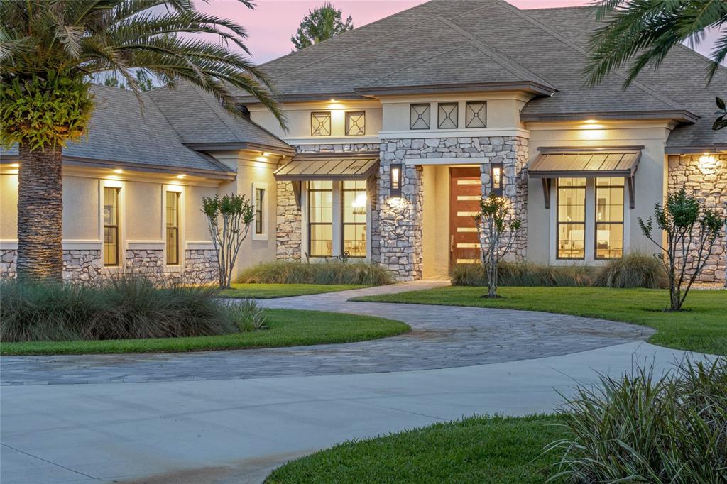 This custom built 5 Bedroom, 4.5 Bath Pool Home is in the gated equestrian community of Seminole Woods!  Seminole Woods offers 1552 acres with 252 homesites on 5 acre lots, miles of horseback trails, a private 12 acre park on skiable Buck Lake w/boat ramp, fishing dock, playground, pavilion, beach & basketball court! Bring your boats & horses! Upon arrival, there is a security gate to the large circular driveway, you will notice the custom pivot front door. The foyer opens to the living room which boasts a 72' linear electric fireplace w/ colored flame features & built-in accent shelves! The dining room has beautiful mirrored coffered ceiling.  The open layout includes the foyer, dining room, wine room, wet bar, living room, kitchen & breakfast area! The wine room holds approx. 100 bottles of wine! The wet bar has a wine fridge & plumbed for an ice maker. The gourmet kitchen is a chef's dream w/ a large center island, induction range w/ pot filler, double built-ovens, Advantium microwave, large farm sink, a closet pantry for small appliances & storage & a walk-in pantry that has an additional refrigerator! The main kitchen refrigerator is a "smart" fridge w/ 2 separate freezers.  There is a slide out shelf on the island that allows for handicap access for food prepping. The home office is just off the foyer & living room.  The master bedroom is spacious w/a sitting area that overlooks the pool & patio! There are two walk in closets w/ custom built-ins & is modified for handicap access. The master bath is a retreat that overlooks a private garden, has a large walk-in shower w/ dual shower heads, large vanity with dual sinks & makeup vanity. The bathroom also features a toilet w/ bidet and a walk-in spa tub.  The master BR has its own solar water heater. Bedrooms 2, 3 & 4 are all spacious w/ walk-in closets.  From the main living area you will find the family/media room that has 2 sets of triple sliding pocket doors that open up to pool & lanai area. Triple stacked sliding doors from the living room also lead out to the outdoor entertaining area that includes an outdoor cooking area/pool/patio/spa.  The 5th bedroom is located within the lanai, and could function as guest suite w/full bath & walk-in closet!  The pool/spa/patio/outdoor kitchen area is something to be seen costing over 200K! The salt water infinity pool (around the entire perimeter) can be heated by solar, a heat pump or propane & is controlled by a Hayward Omni Logic control system. The beautiful pebble tec finish is accented by 2 large fire bowls, 4 water features & LED lighting! The heated spa accommodates 6-8 people & is accented w/ built in lounge chairs. The cooking center features a Fire Magic gas grill, 120 BTU power burner, garbage disposal, & refrigerator. The 3 car tandem garage has a workshop, TESLA 80 amp charging station, RV hookup, attic storage.  Connecting the 2 garages is a 3 car wide porte corchere & outdoor parking space! There is a new RV parking pad next to the garage. Large laundry room w/folding counter & storage closet. Electric window shades throughout, crown molding, 10 & 12 ft. ceilings, blue tooth ceiling fans, 3 AC units, 2 septics, 2 propane tanks, whole house sound system, security system, massive attic storage w/ lights & a catwalk bridge, deep well irrigation system, ozone generator, landscape lighting, tankless water heaters. Have I mentioned the solar array system for the home - sellers electric bill runs around $100 monthly! PARADISE! Room Feature: Linen Closet In Bath (Primary Bathroom).