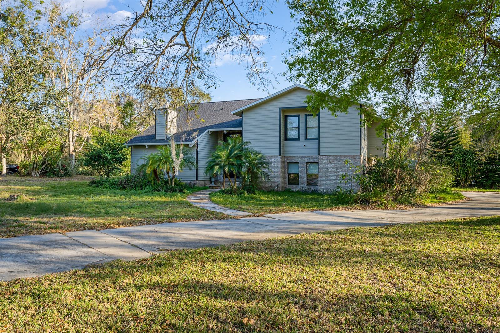 Great location - Hidden Hills subdivision! This unique home sits on a sprawling 1.19 acre lot with pond frontage and plenty of room to spread out. The very generous master bedroom has an attached area to use for reading nook, office, library, etc. and also a private deck overlooking the screened pool enclosure. The master bath has a large tub, separate standup shower and double vanity. There are two additional bedrooms and a full bath on this floor and just a few steps up to the spacious and bright loft. There is a second master on the lower floor with full en-suite bath and walk in closet. The bright main floor offers gorgeous hardwood floors throughout, vaulted ceilings, separate dining room, kitchen with breakfast area and sliders opening to the outdoor space. Your sprawling pool enclosure offers more than 2,500 sq ft of area to entertain complete with cabana bar, pool bath and sauna room. The possibilities are endless on this property. Easy access to I-95, space center, and central Florida attractions, yet tucked away for privacy. Don't let this one get away!