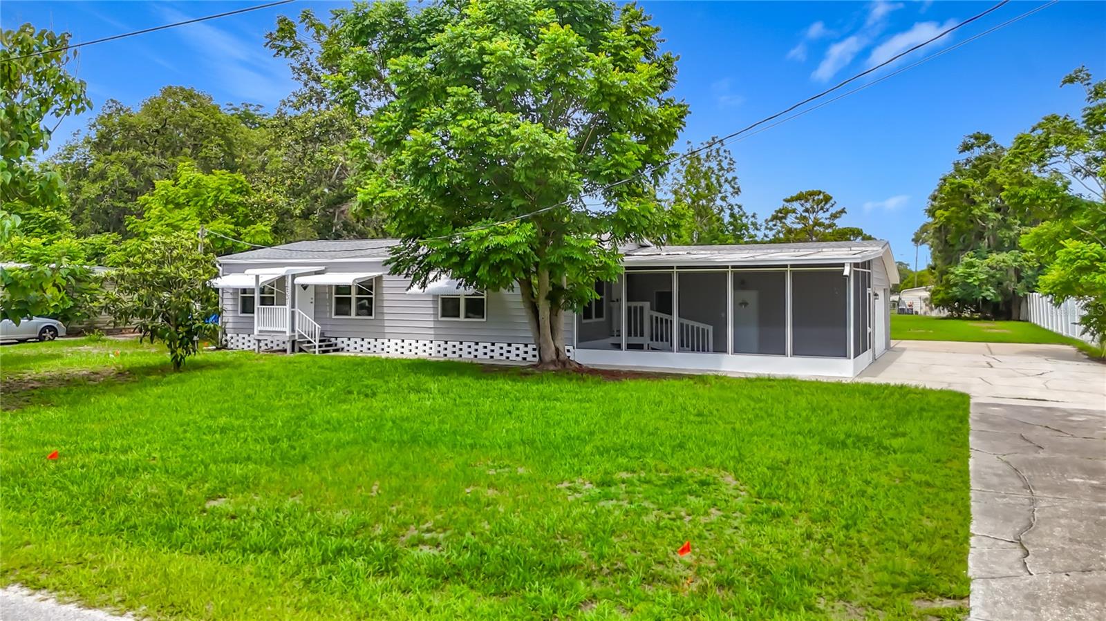 Welcome to a rare find that truly stands out from the crowd. This 1987 double-wide, 2-bedroom, 2-bath, ATTACHED 2 CAR GARAGE Home has been completely renovated from top to bottom and is move in ready.  This home sits on nearly half an acre & offers the look and quality of new construction without the new construction price tag. From the moment you step inside, you'll appreciate the attention to detail. The home features sheetrock walls throughout, crown molding, matching ceiling fans, luxury vinyl flooring, new baseboards, fresh lighting, and beautifully updated bathrooms. The stunning kitchen is complete with quartz countertops, stainless steel appliances, dishwasher and modern finishes that make everyday living a pleasure. Both bedrooms feature brand-new carpeting, while the bathrooms have been completely remodeled with new vanities, sinks, mirrors, toilets, and showers. The spacious primary suite includes a walk-in closet and a private bath with a tub/shower combination. The beautifully renovated hall bathroom features a walk-in tiled shower, new vanity, updated flooring, and modern fixtures throughout, it also offers the convenience in design to accommodate a full-size washer and dryer.  Major improvements provide peace of mind, including a NEW ROOF 2024 & NEW AC system in 2025.  Need extra space? The attached garage features its own mini-split AC system, creating endless possibilities for a family room, game room, hobby space, home office, or additional living area. Outside, the possibilities are endless. With nearly half an acre of cleared flat land, there's room for a pool, workshop, RV, boat, chickens, gardening, and more. The screened porch provides the perfect place to relax and enjoy Florida living. Enjoy the peaceful feel of country living while remaining close to everyday conveniences.  Hudson's waterfront restaurants, tiki bars, marina's, live entertainment and Gulf Coast Sunsets are approximately 10 miles away. Clearwater Beach, Honeymoon Island, St. Pete all withing an hour drive making this the perfect balance of privacy recreation and accessibility. This home is close to State Road 52 with easy access to the Suncoast Parkway, Tampa, shopping, dining, hospitals are all within reach. Homes offering this level of renovation with land & location are incredibly hard to find. This is not your typical manufactured home—it's an exceptional property that shows beautifully and must be seen in person to be fully appreciated. Don't delay Call me Today!!